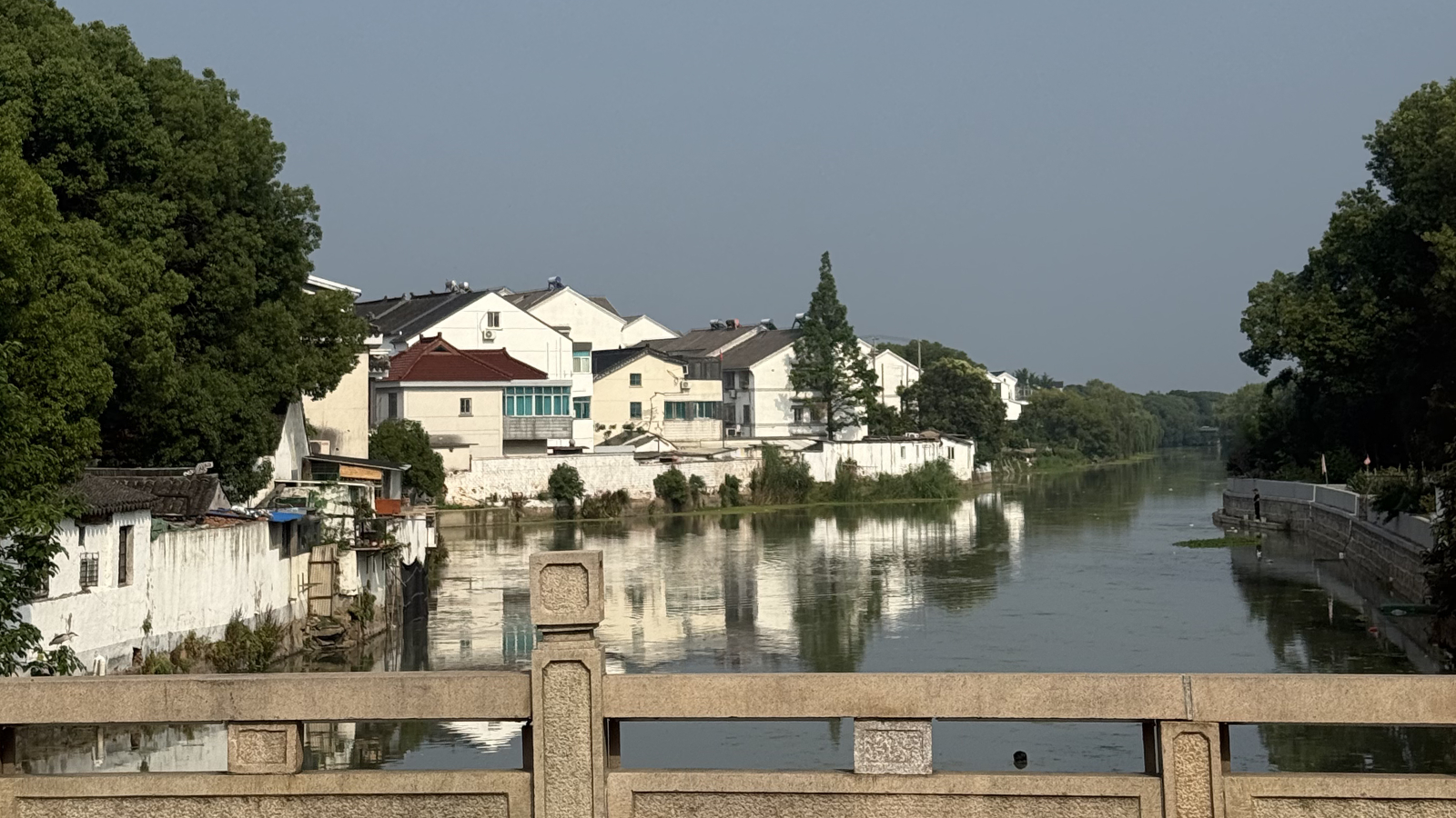 Whitewashed houses lean over the riverbank in Tongli Water Town, Jiangsu Province. /Zaruhi Poghosyan
