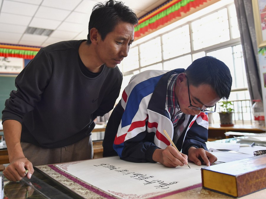 Ngogyan Tenzin (R) practices Tibetan calligraphy at Lhasa-Jiangsu Experimental Middle School in Lhasa, capital of southwest China's Xizang Autonomous Region, September 14, 2023. /Xinhua