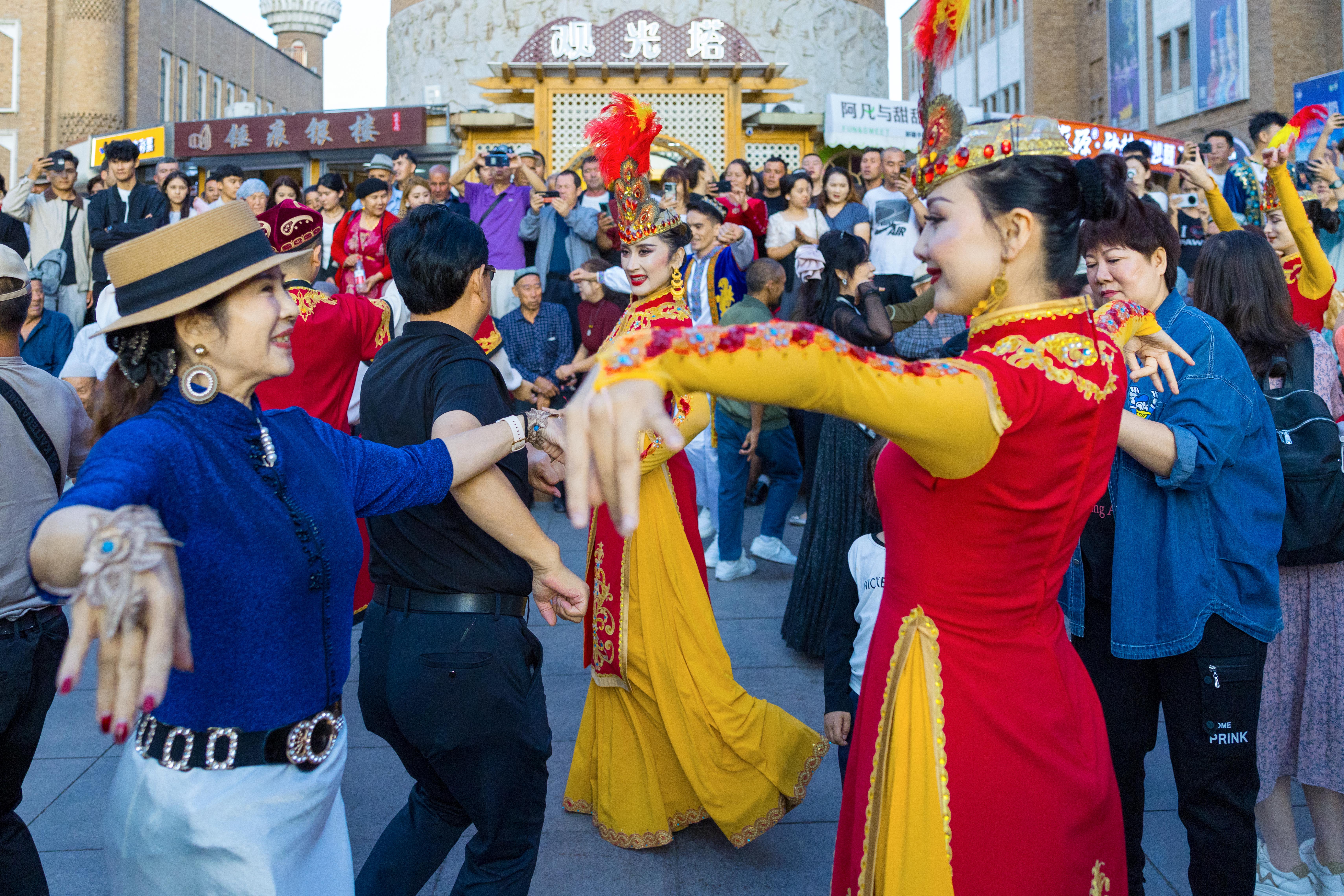Visitors and local performers dance together at the International Grand Bazaar in Urumqi, northwest China's Xinjiang Uygur Autonomous Region, September 12, 2025. /IC