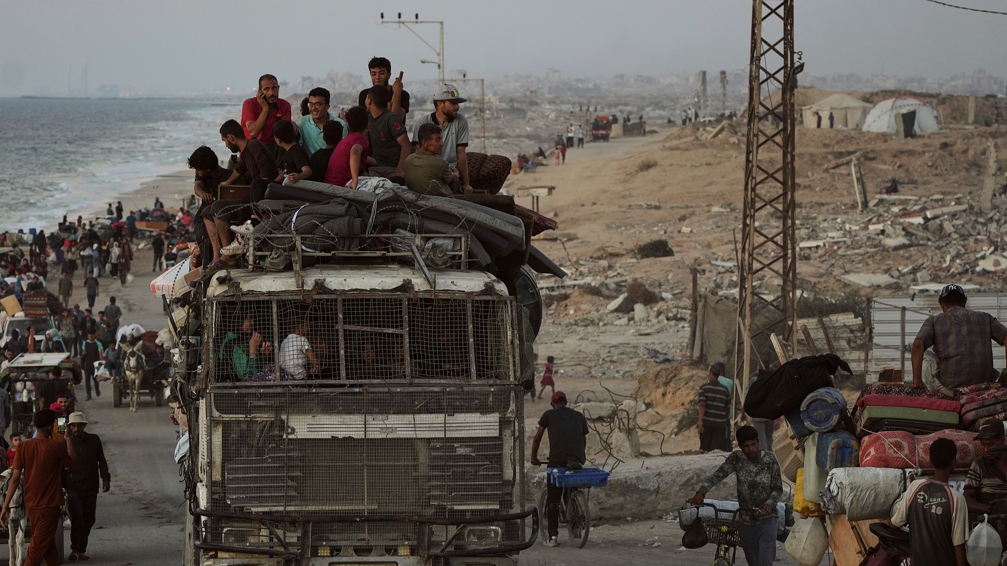 Displaced Palestinians flee Gaza City carrying their belongings along the coastal road toward southern Gaza, September 17, 2025. /VCG