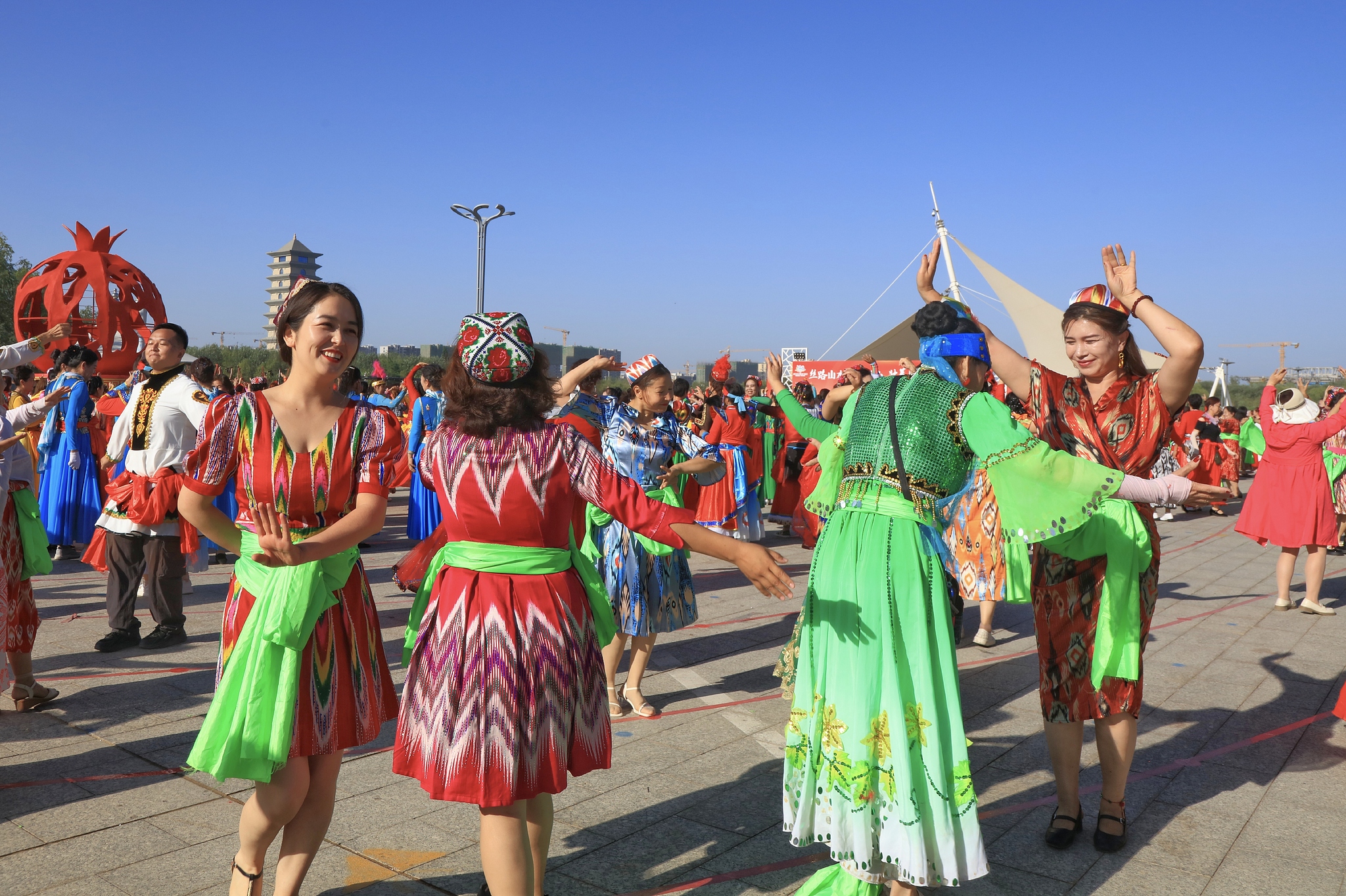 People from various ethnic groups sing and dance in a plaza in Korla City, Bayingolin Mongolian Autonomous Prefecture, northwest China's Xinjiang Uygur Autonomous Region, June 17, 2024. /VCG