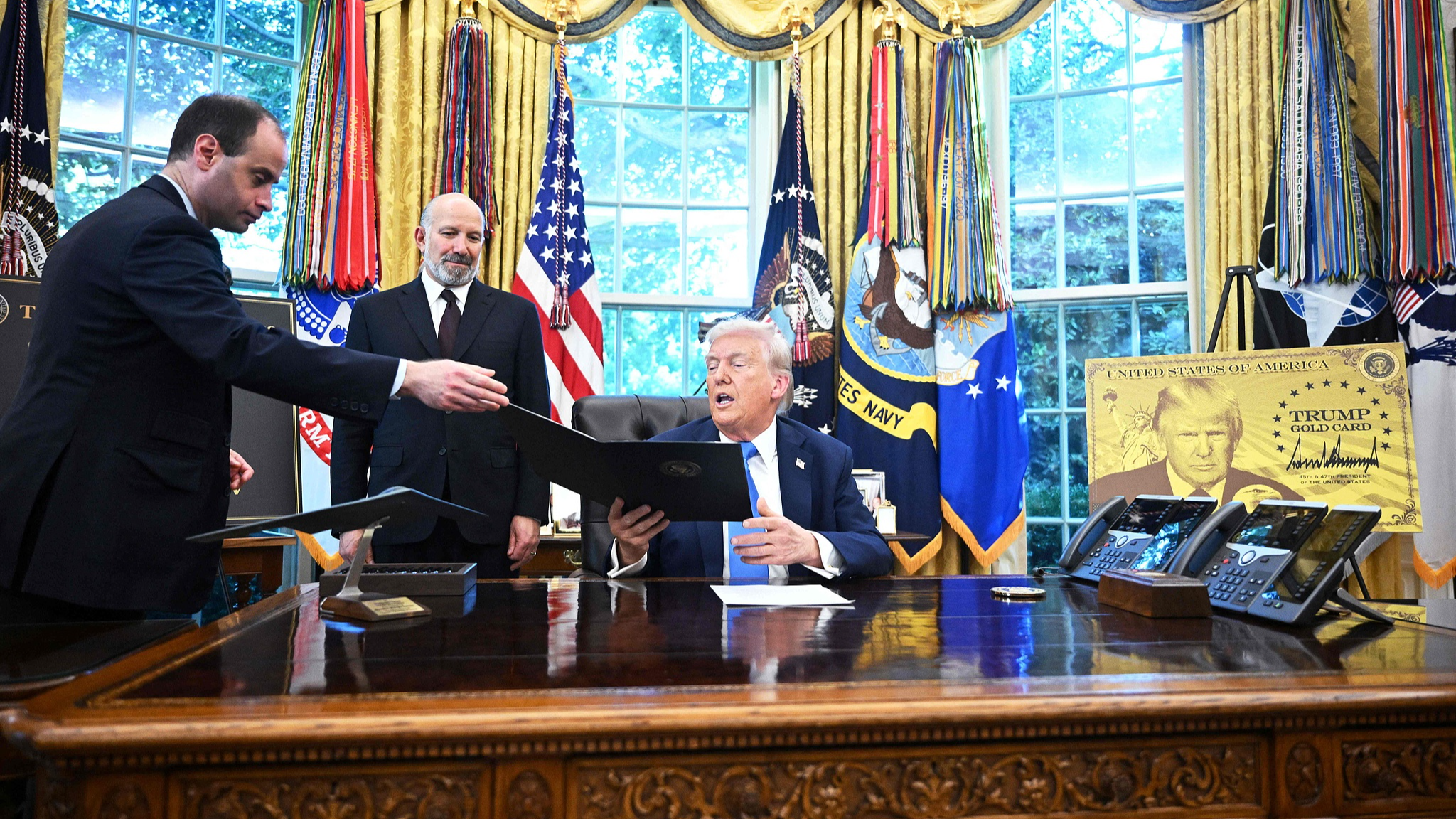 White House Staff Secretary Will Scharf (L) hands an executive order to U.S. President Donald Trump to sign in the Oval Office of the White House in Washington, D.C., U.S., September 19, 2025. /VCG