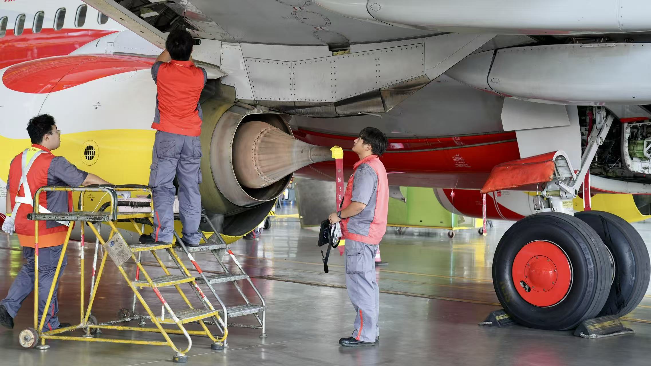 Employees work on a plane at the Hainan Free Trade Port One-Stop Aircraft Maintenance Industrial Base in Hainan, China, September 23, 2025. /CGTN
