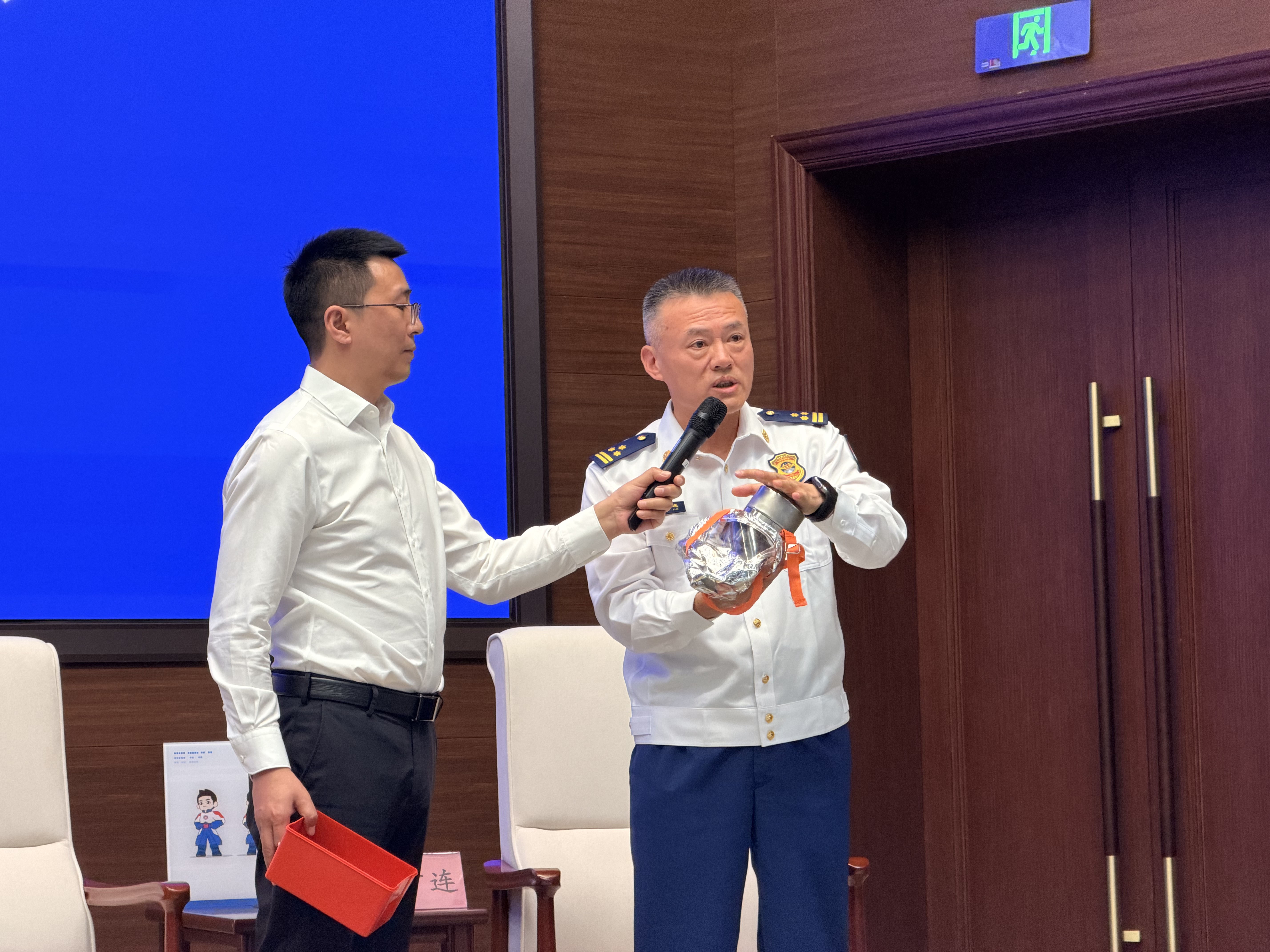 Commander Zhou demonstrates how to put on a fire, smoke, and toxic gas protective mask at a press conference, September 29, 2025. /CGTN
