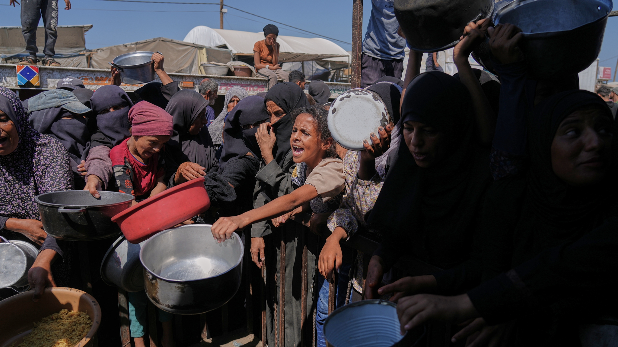 Palestinians struggle to get donated food at a community kitchen in Khan Younis, southern Gaza Strip, September 27, 2025. /VCG