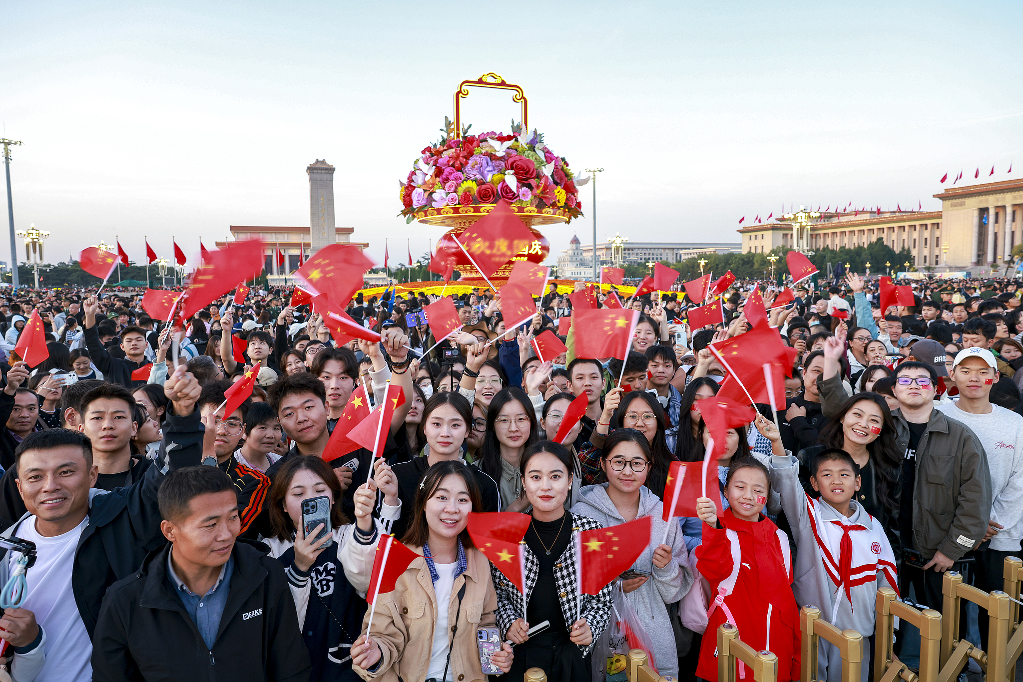 People pose for a photo after a flag-raising ceremony marking the 76th anniversary of the founding of the People's Republic of China at Tiananmen Square in Beijing, capital of China, October 1, 2025. /VCG