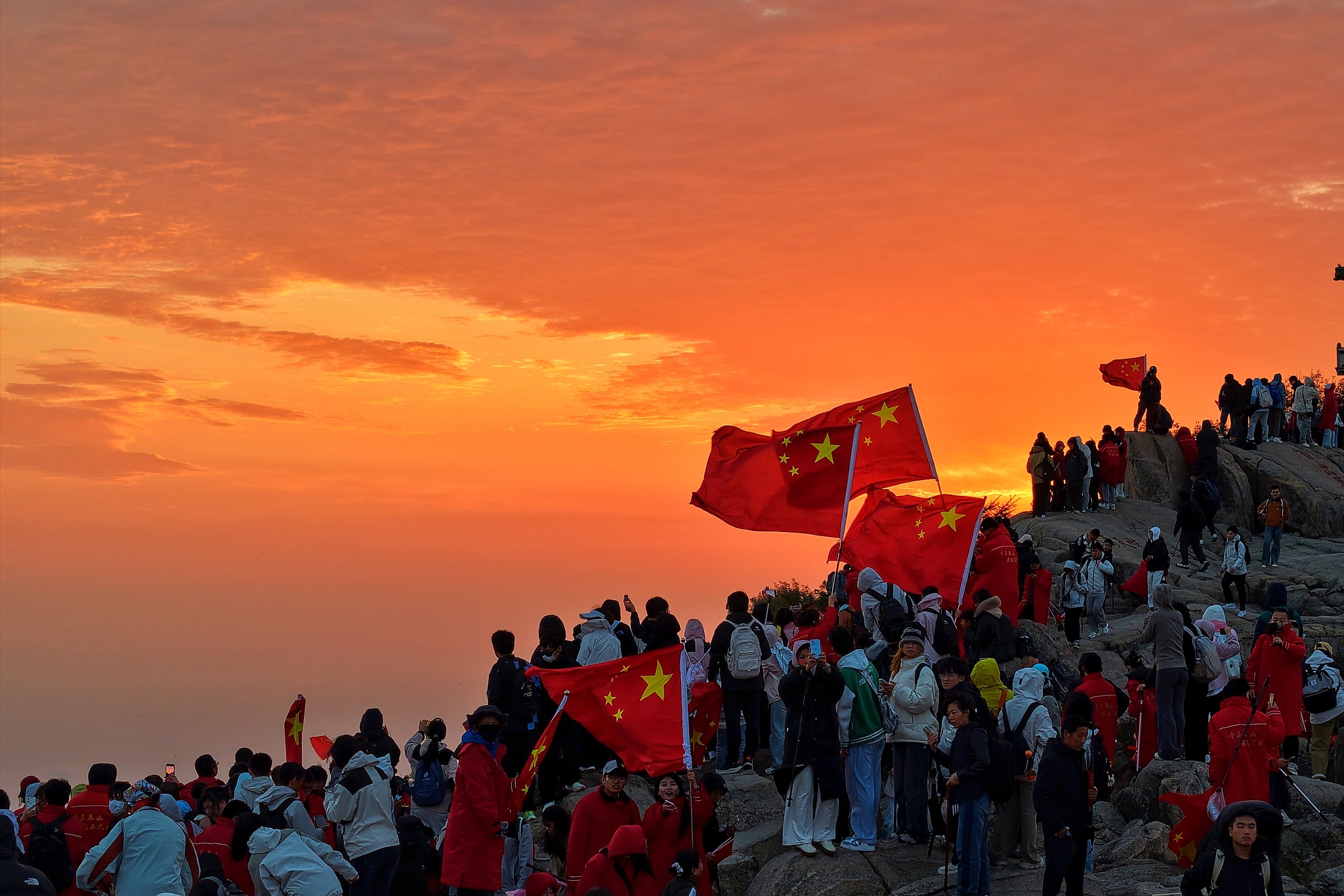 People gather at the summit of Mount Taishan to celebrate the 76th anniversary of the founding of the People's Republic of China in Taian, east China's Shandong Province, October 1, 2025. /VCG