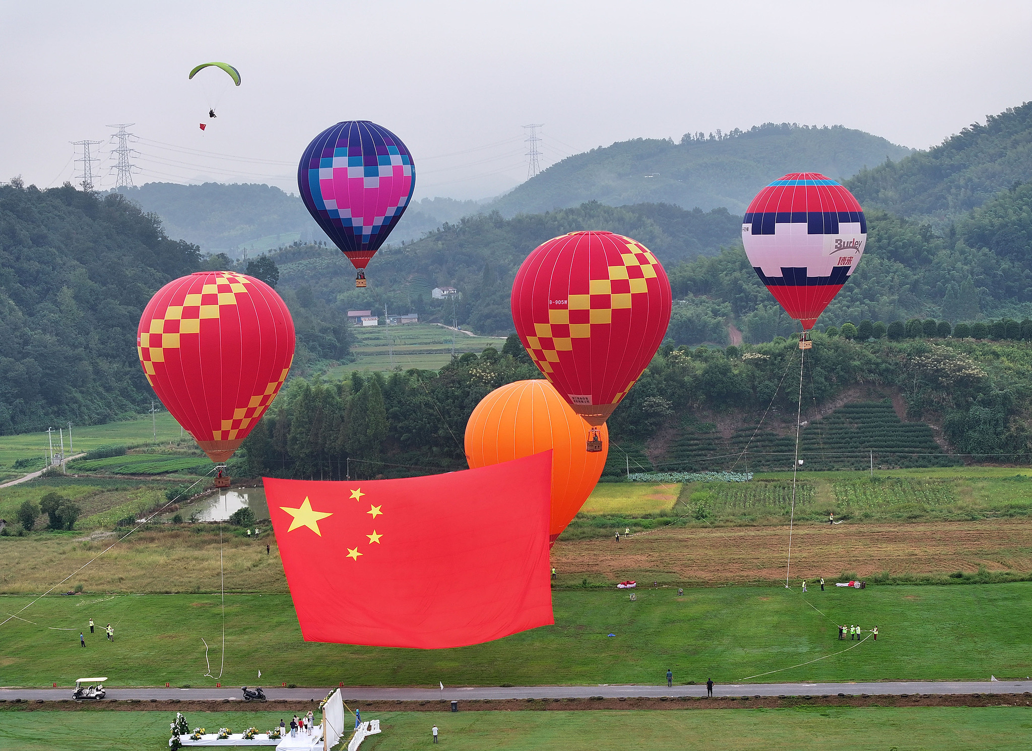 A huge national flag is raised into the air using hot air balloons to celebrate the 76th anniversary of the founding of the People's Republic of China in Jinhua, east China's Zhejiang Province, October 1, 2025. /VCG