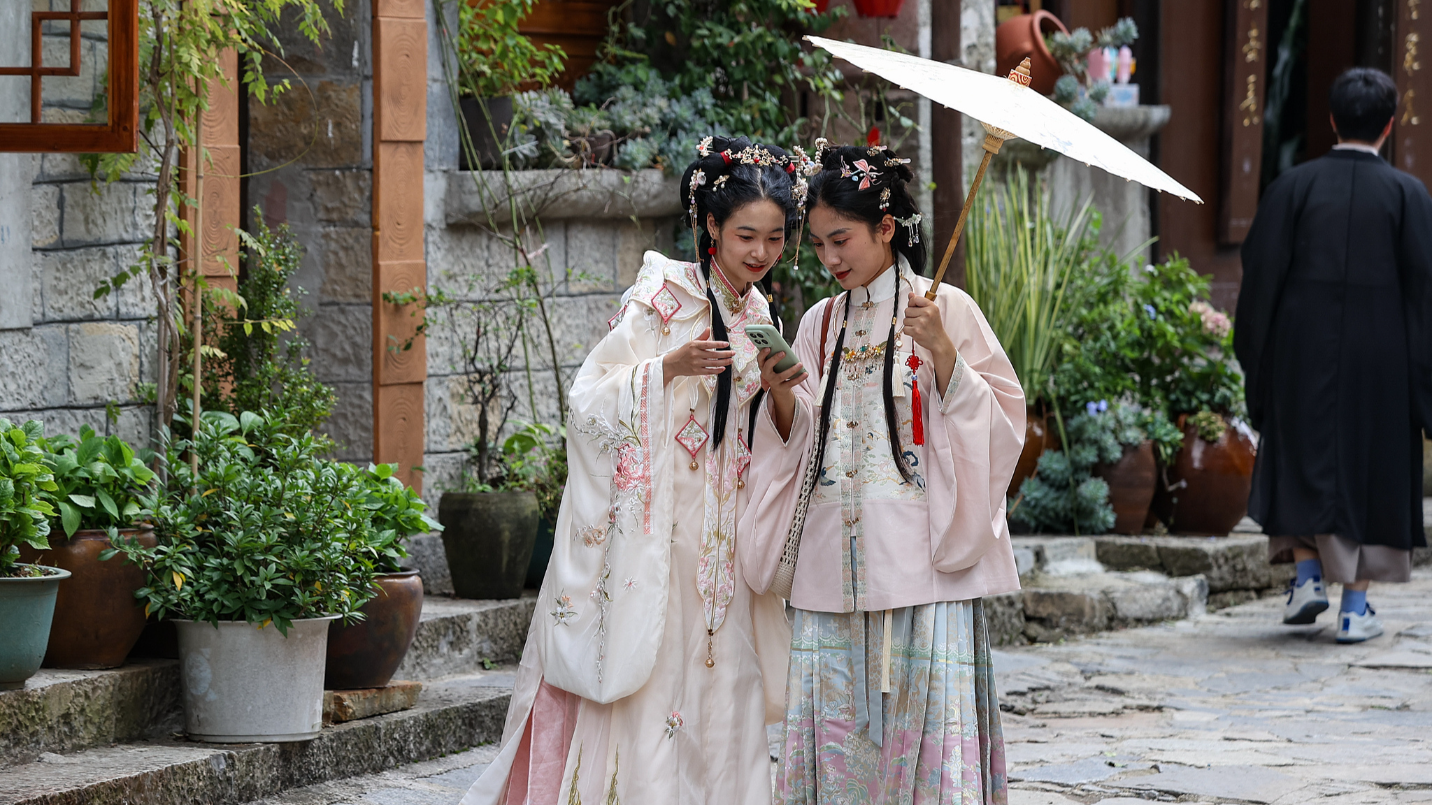 Visitors explore Yunshantun Village in traditional Chinese clothes, known as hanfu, Guizhou Province, China, October 2, 2025. /VCG