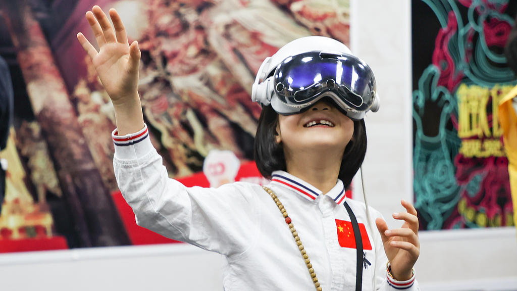 A girl experiences an MR exhibition at Tiefo Temple, Shanxi, China, October 3, 2025. /VCG