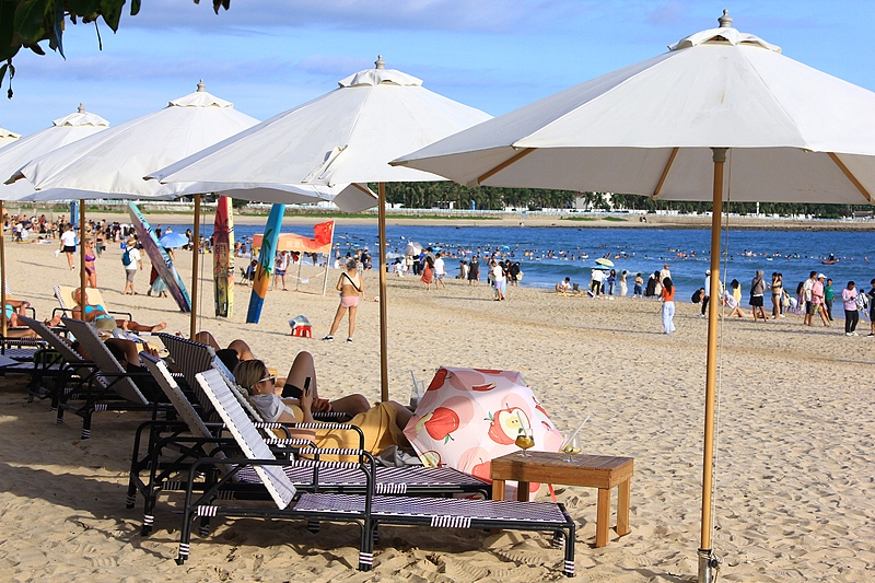 Tourists enjoy themselves at Dadonghai scenic area in Sanya, south China's Hainan Province, October 1, 2025. /VCG