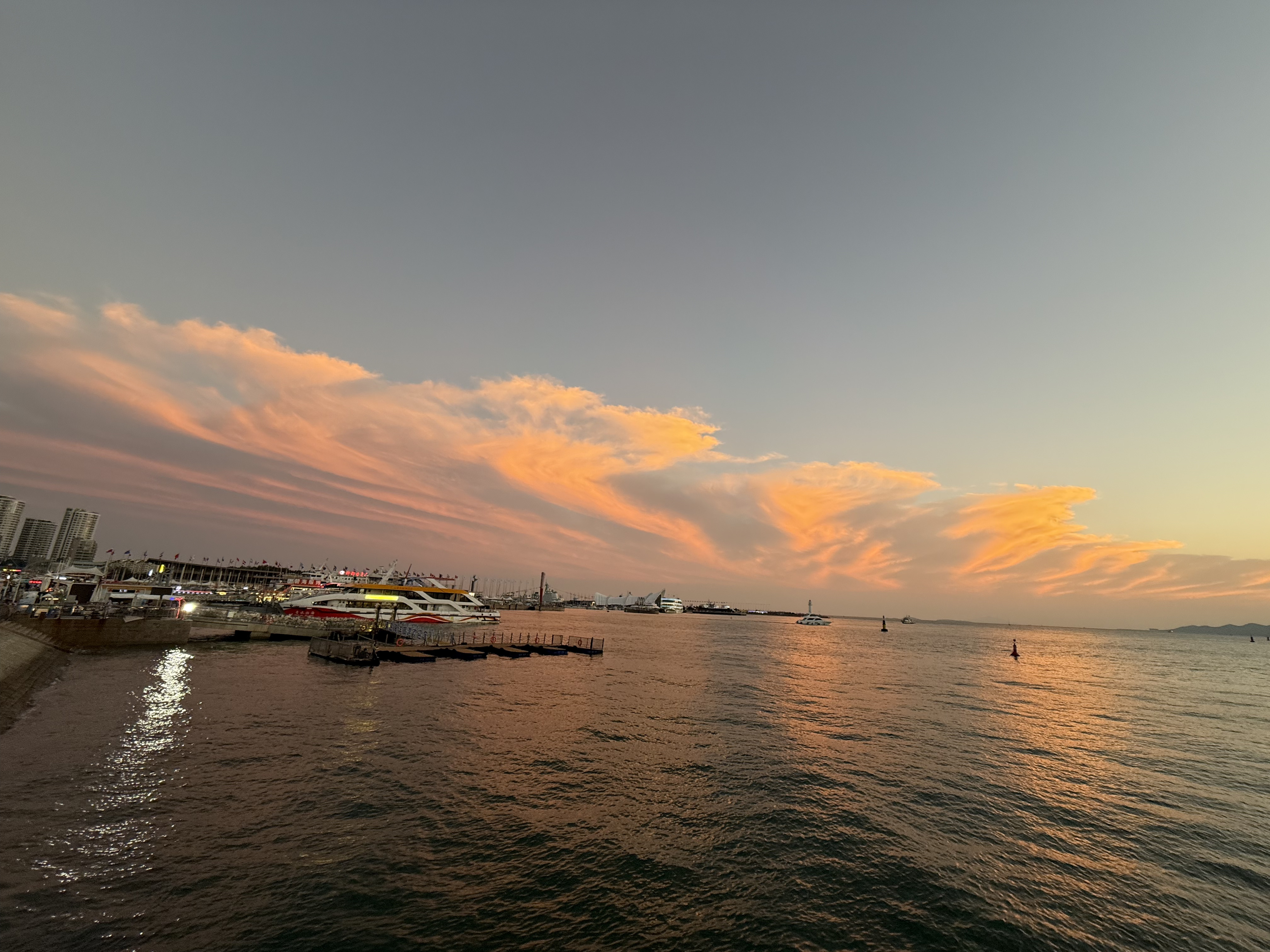 Dusk settles over the sea as ships drifts across the horizon, September 2025, Qingdao, China /Zaruhi Poghosyan