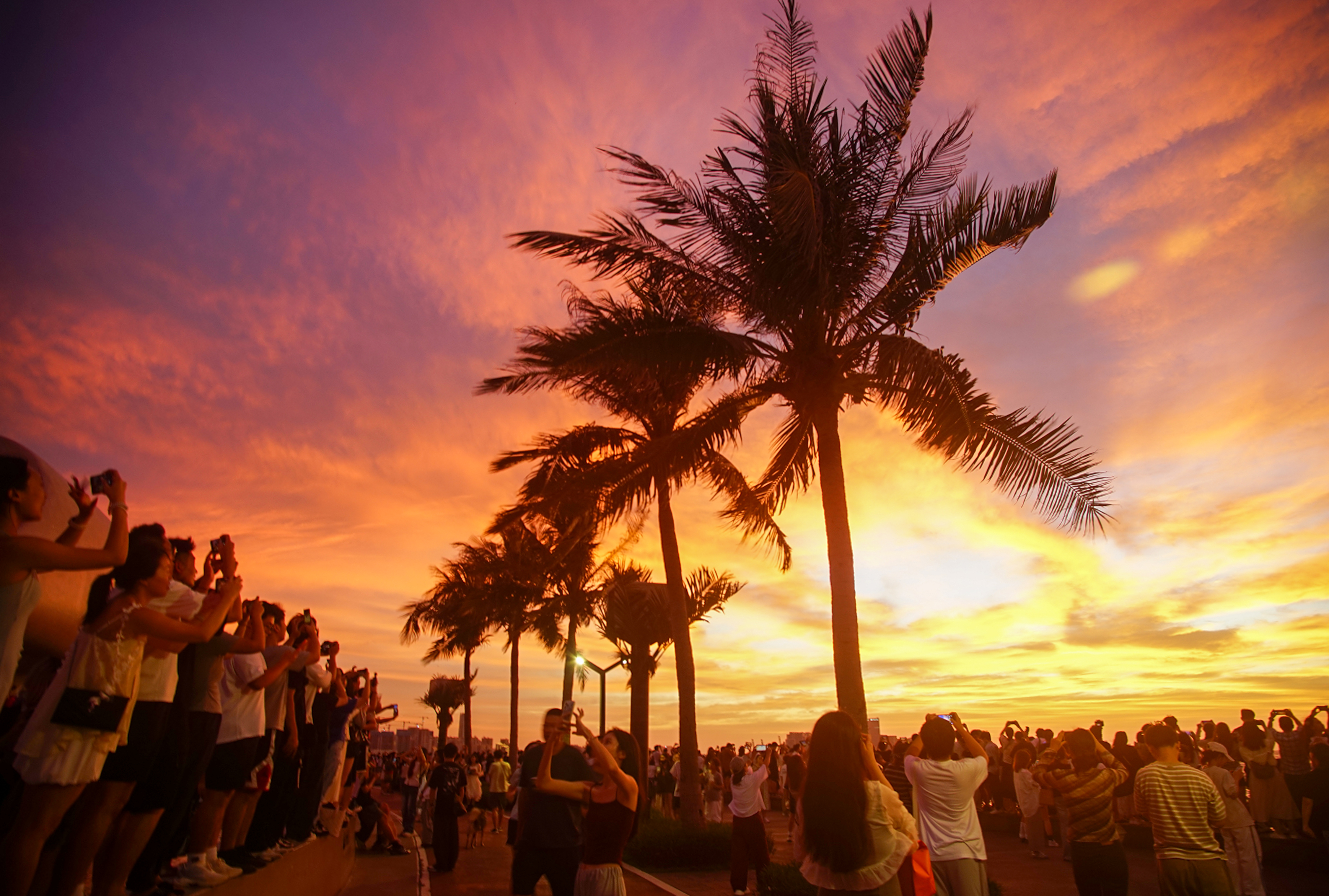 Tourists watch the magnificent sunset in Haikou, south China's Hainan Province, October 4, 2025. /VCG
