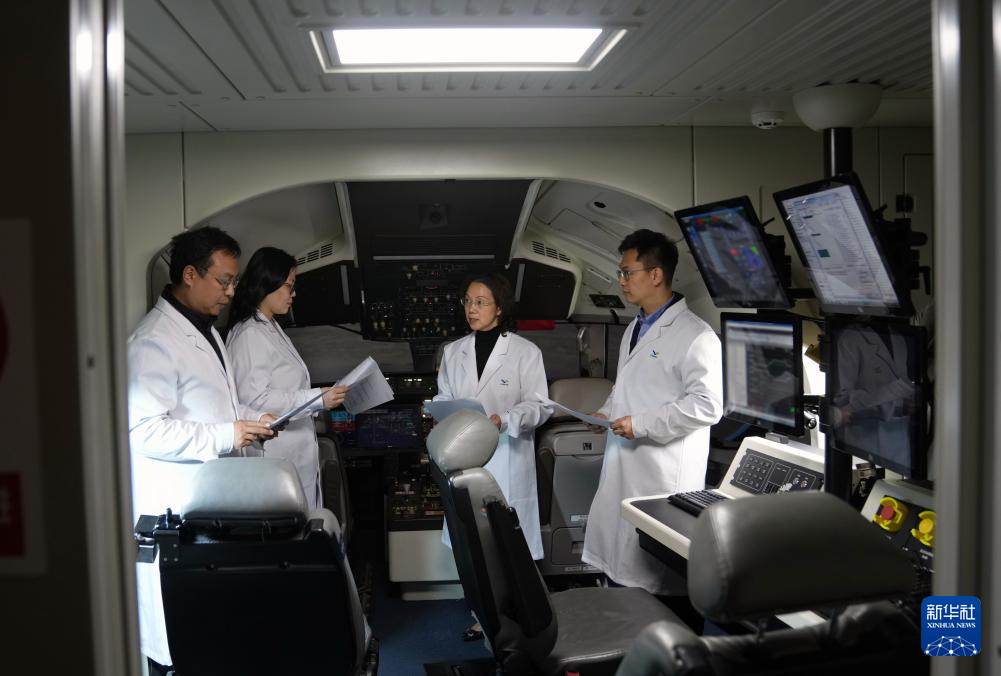 Zhao Chunling (second from right) works with team members inside the C919 engineering simulator, March 5, 2025. /Xinhua
