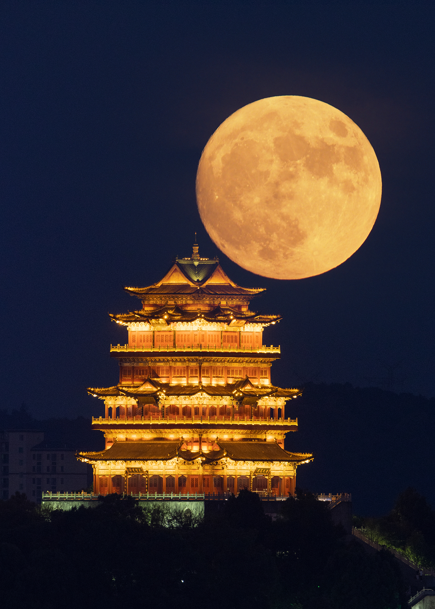 A supermoon is pictured near the Dehua Tower in Jiujiang, Jiangxi Province. /VCG