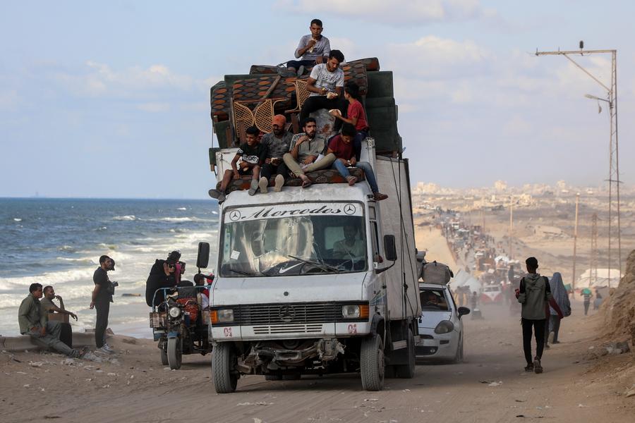 Displaced Palestinians move with their belongings along the sea shore near the al-Nuseirat area in the central Gaza Strip, September 25, 2025. /Xinhua
