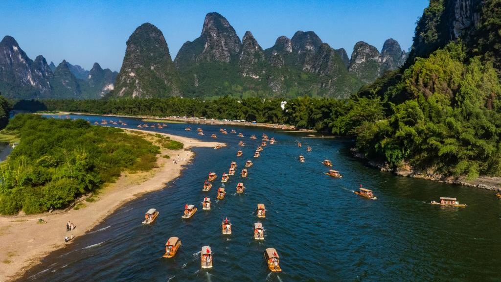An aerial drone photo taken on October 4, 2025 shows tourists enjoying the scenery on bamboo rafts along the Lijiang River in Yangshuo County, south China's Guangxi Zhuang Autonomous Region. /Xinhua