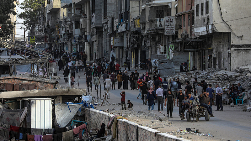 Palestinians walk at Al Remal neighbourhood during an Israeli military operation in Gaza City, Gaza Strip, October 5, 2025. /VCG