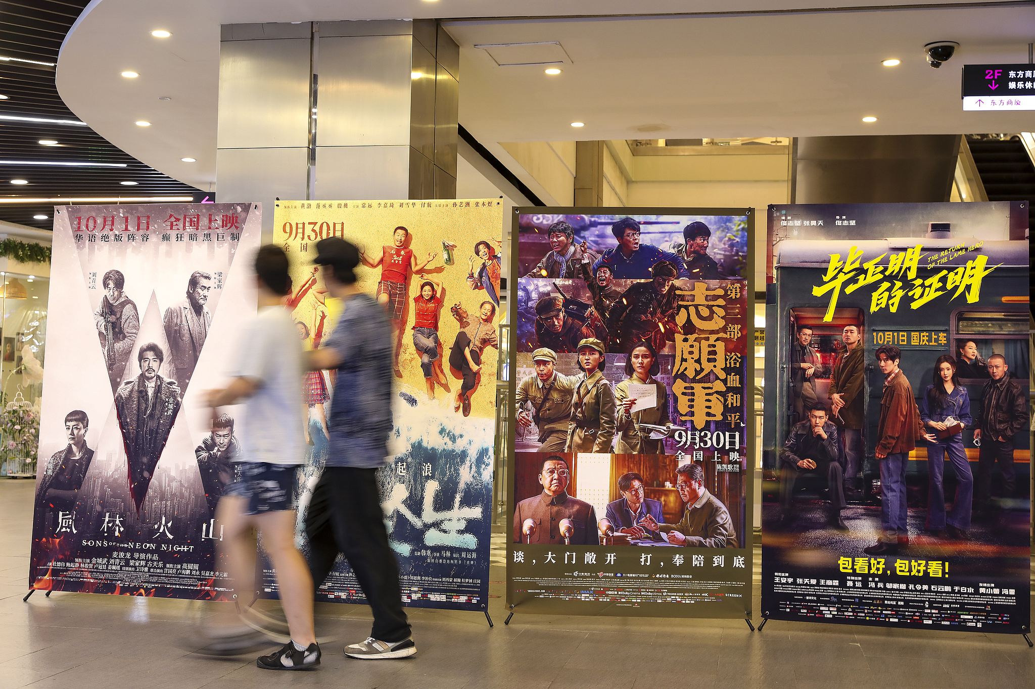 Visitors walk by movie posters in a movie theater in Shanghai, China, October 8, 2025. /VCG