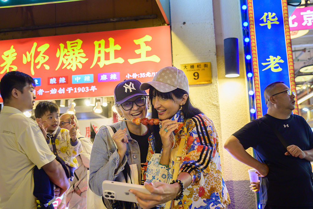 Foreign tourists visit Qianmen Street, a historic and famous commercial pedestrian street in Beijing, capital of China, September 26, 2025. /VCG