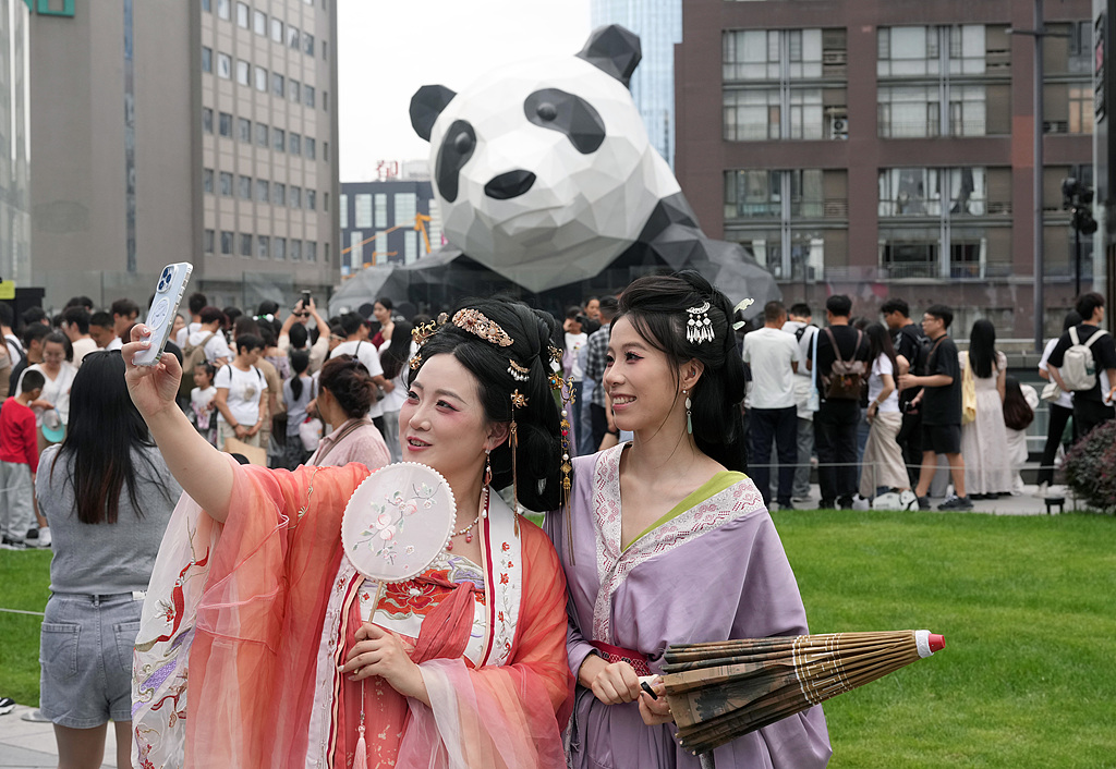 Visitors take photos at a giant panda sculpture on Chunxi Road, a pedestrianized shopping street in Chengdu, southwest China's Sichuan Province, October 3, 2025. /VCG