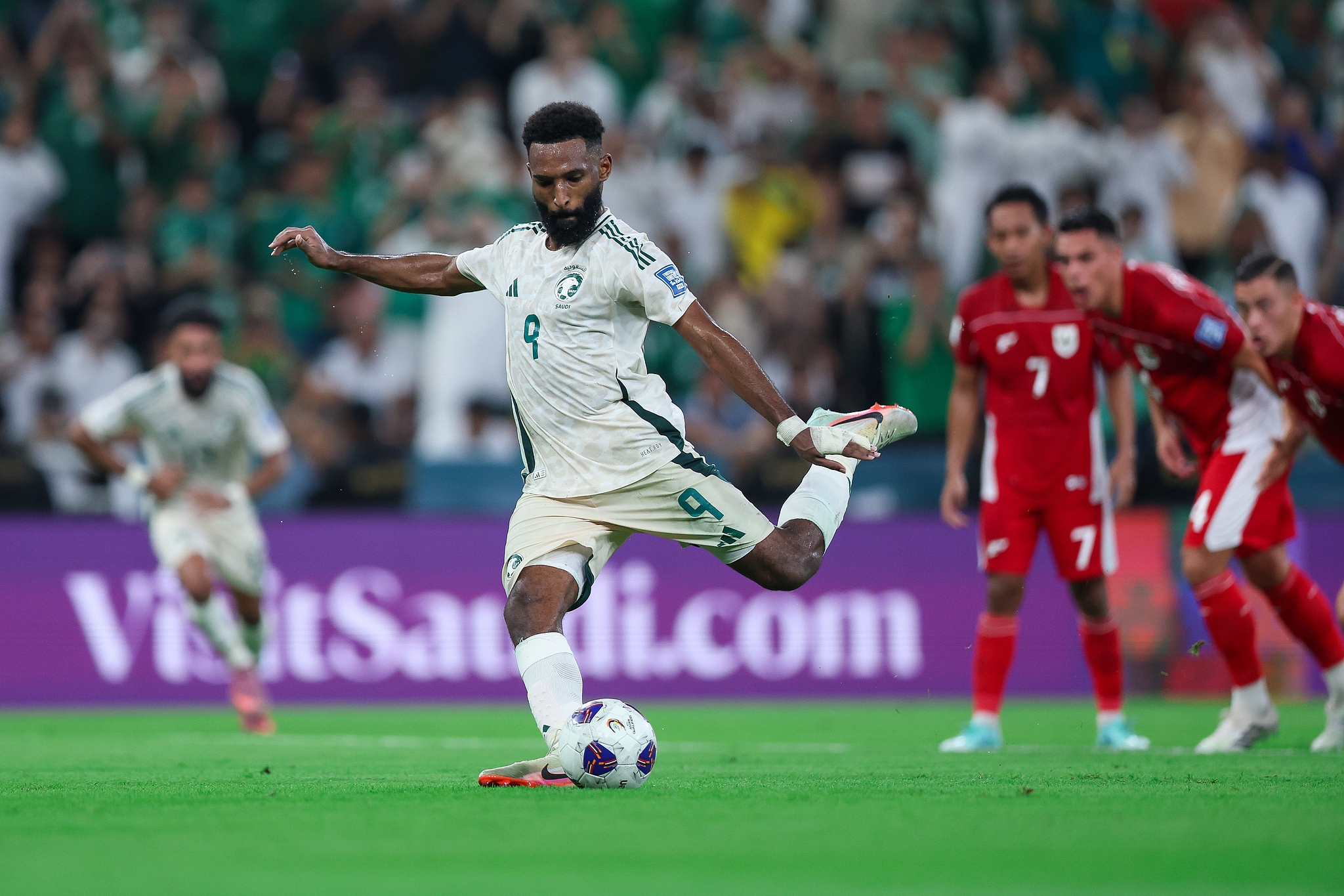 Saudi Arabia's Feras Al-Brikan (C) drills a penalty kick against Indonesia in a 2026 FIFA World Cup Asian Qualifier at the King Abdullah Sports City in Jeddah, Saudi Arabia, October 8, 2025. /VCG
