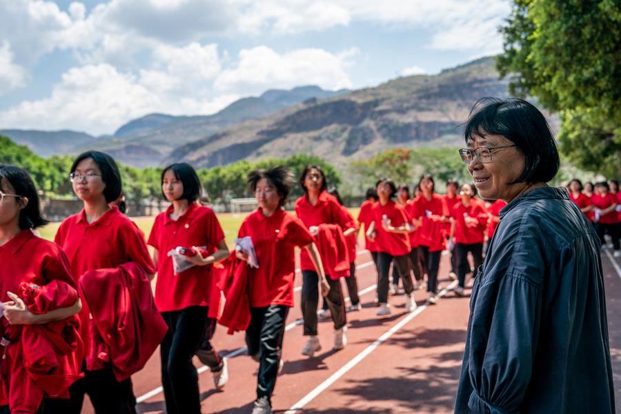 Zhang Guimei (R), principal of the Huaping Senior High School for Girls, looks at her students returning to school after they taking a national college entrance examination in Lijiang, Yunnan Province in southwest China, June 7, 2024. /Xinhua