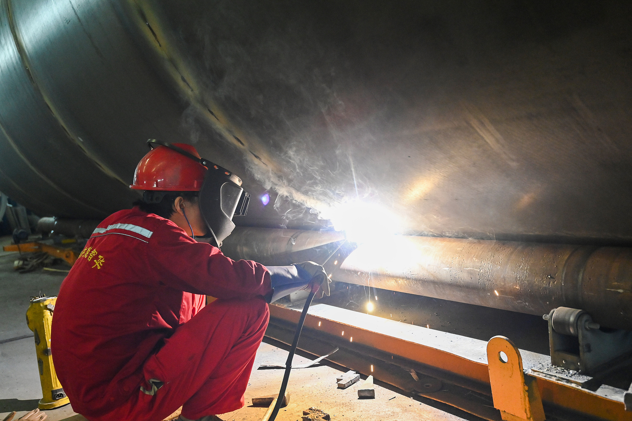 A worker is welding large pressure vessels at a workshop in Qingzhou City, east China's Shandong Province on October 9, 2025. /VCG