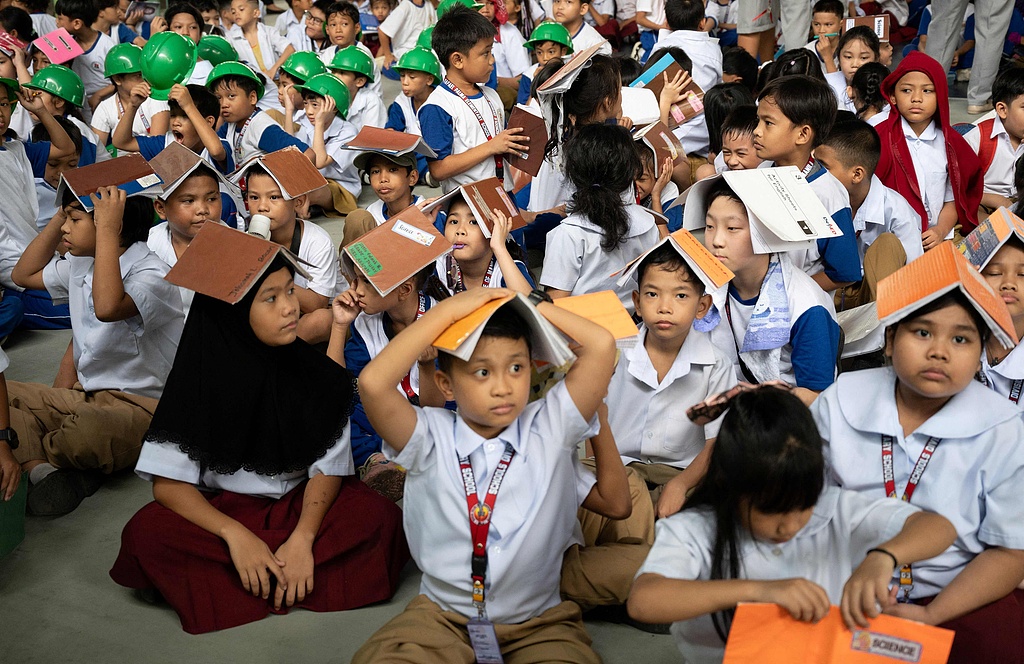 Primary school students gather at the designated evacuation center outside the teaching building and hold an earthquake drill in Manila, Philippines. September 11, 2025. /CFP