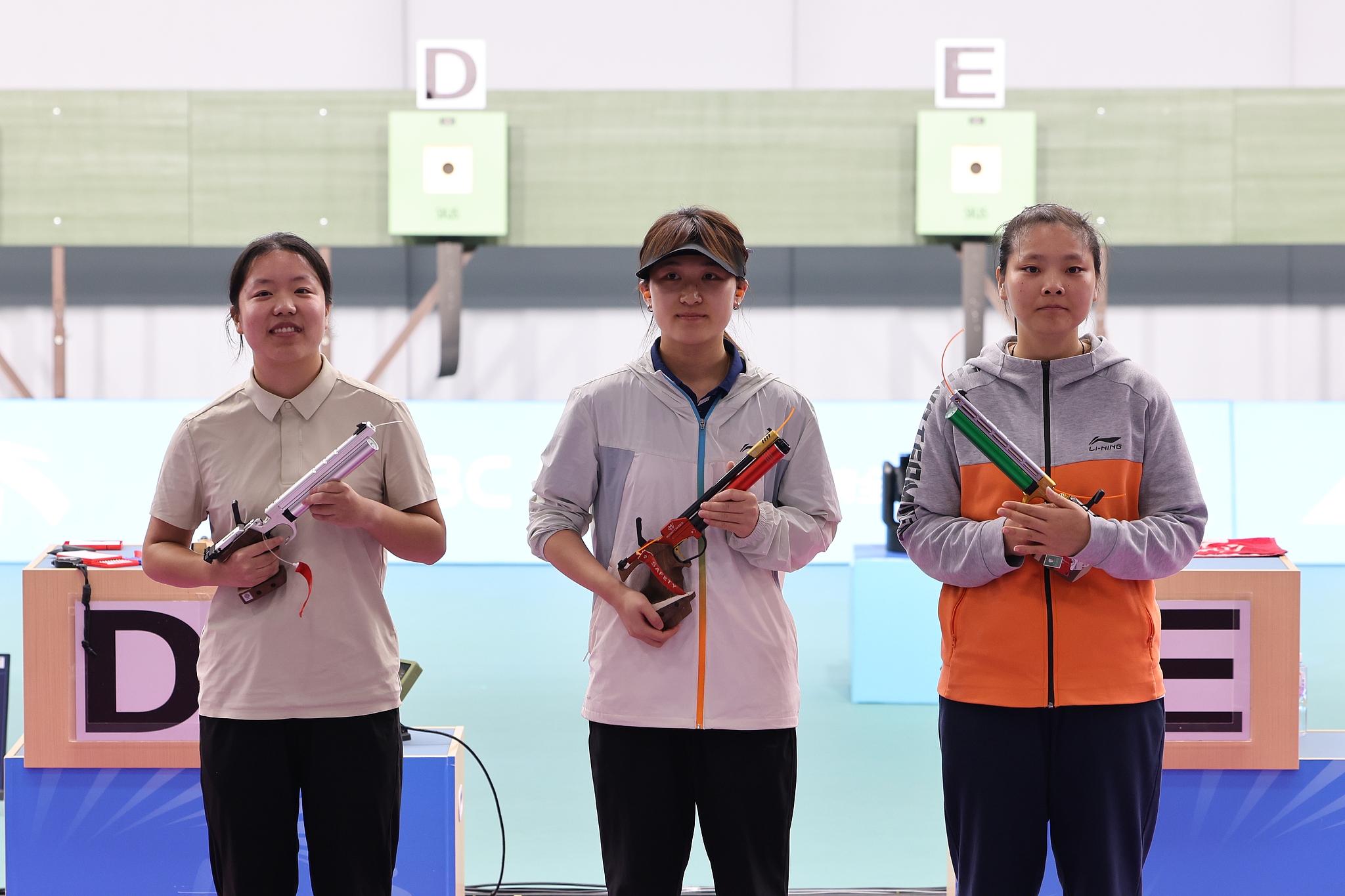 L-R: Silver medalist Ruan Mengying, gold medalist Tang Xiao and bronze medalist Jiang Ranxin pose for photos after competing in the women's 10-meters air pistol final at the 15th National Games of China in Guangzhou, south China's Guangdong Province, October 16, 2025. /VCG