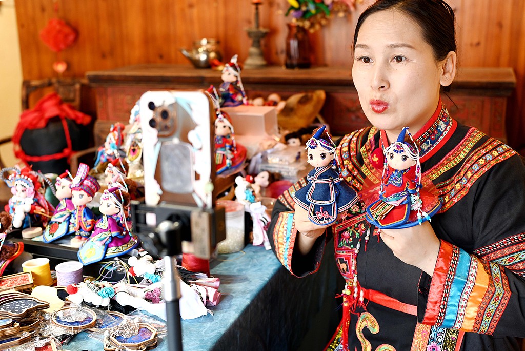 Lan Xiaoyan, a She ethnic intangible cultural heritage inheritor in Zhejiang, introduces lucky dolls during her livestream on July 10, 2025. /VCG