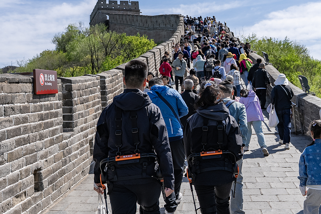 Climb like never before: Visitors wear exoskeleton robots to assist uphill and ensure controlled descent at the Badaling section of the Great Wall, Beijing, May 1, 2025. /VCG
