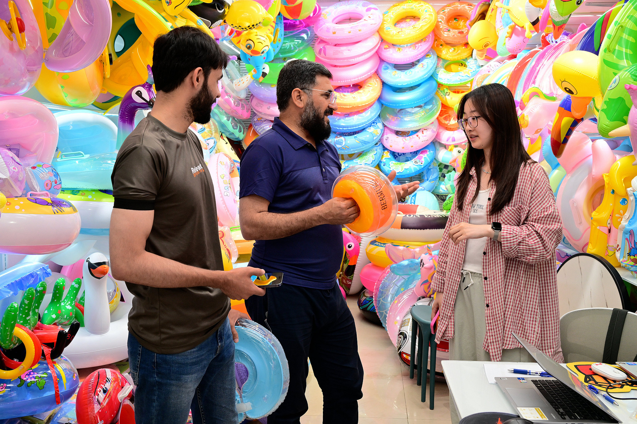 Foreign businessmen and a merchant negotiate the purchase of inflatable swimming rings at Yiwu International Trade Market in Yiwu, east China's Zhejiang Province, May 25, 2025. /VCG