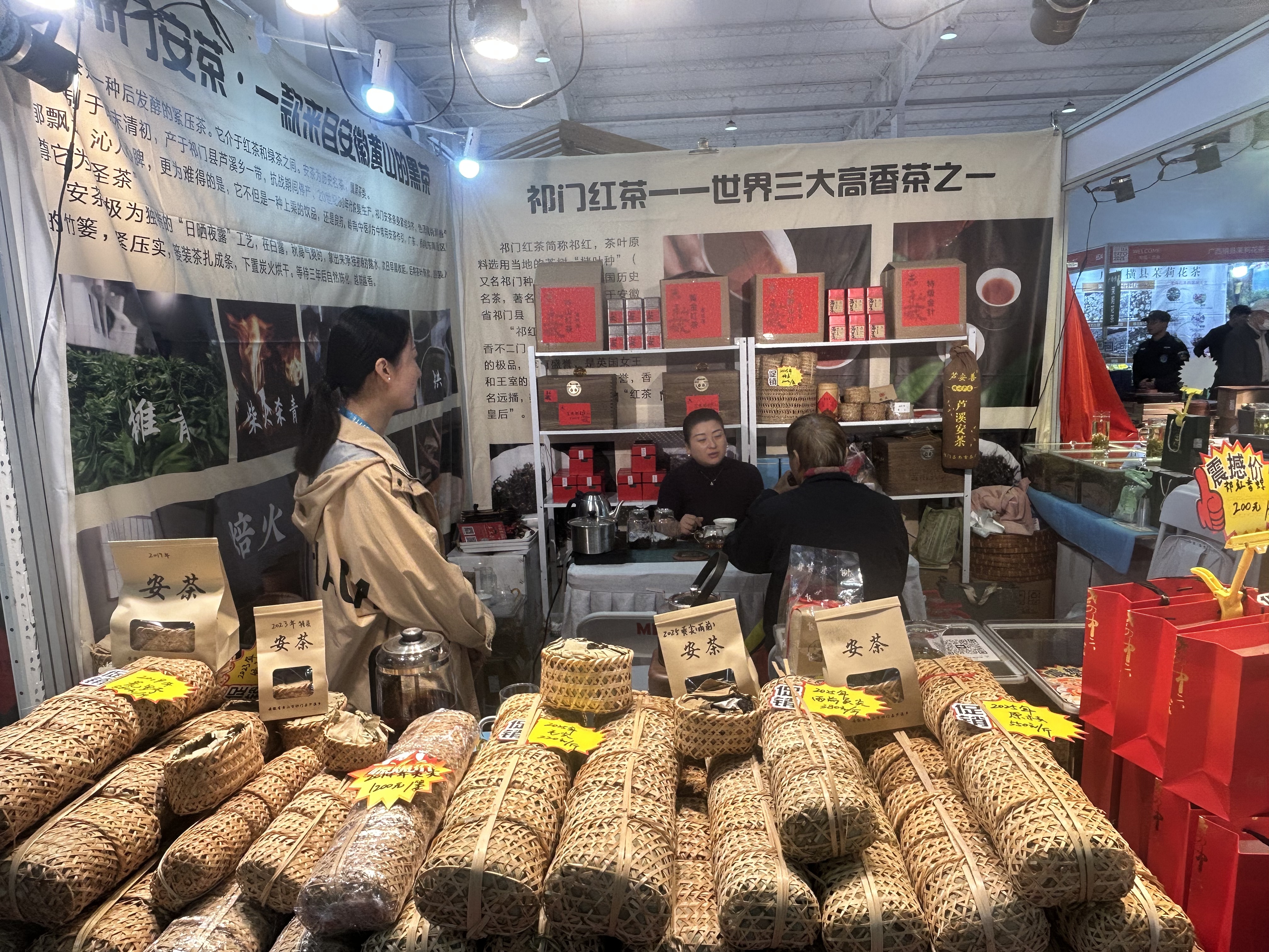 A black tea stall owner chats with a tea lover, explaining the benefit of drinking Keemun black tea, one of the most famous Chinese teas with an intensive aroma, at the ongoing Beijing International Autumn Tea Industry Trade Expo on Friday, October 17, 2025. /CGTN