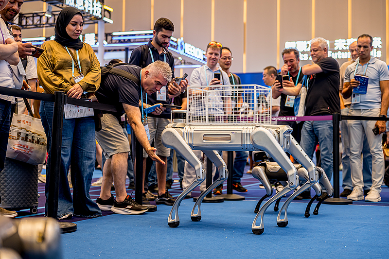 Visitors from abroad gather to observe the robotic dog showcase at the Canton Fair from October 17 to 18, 2025./VCG