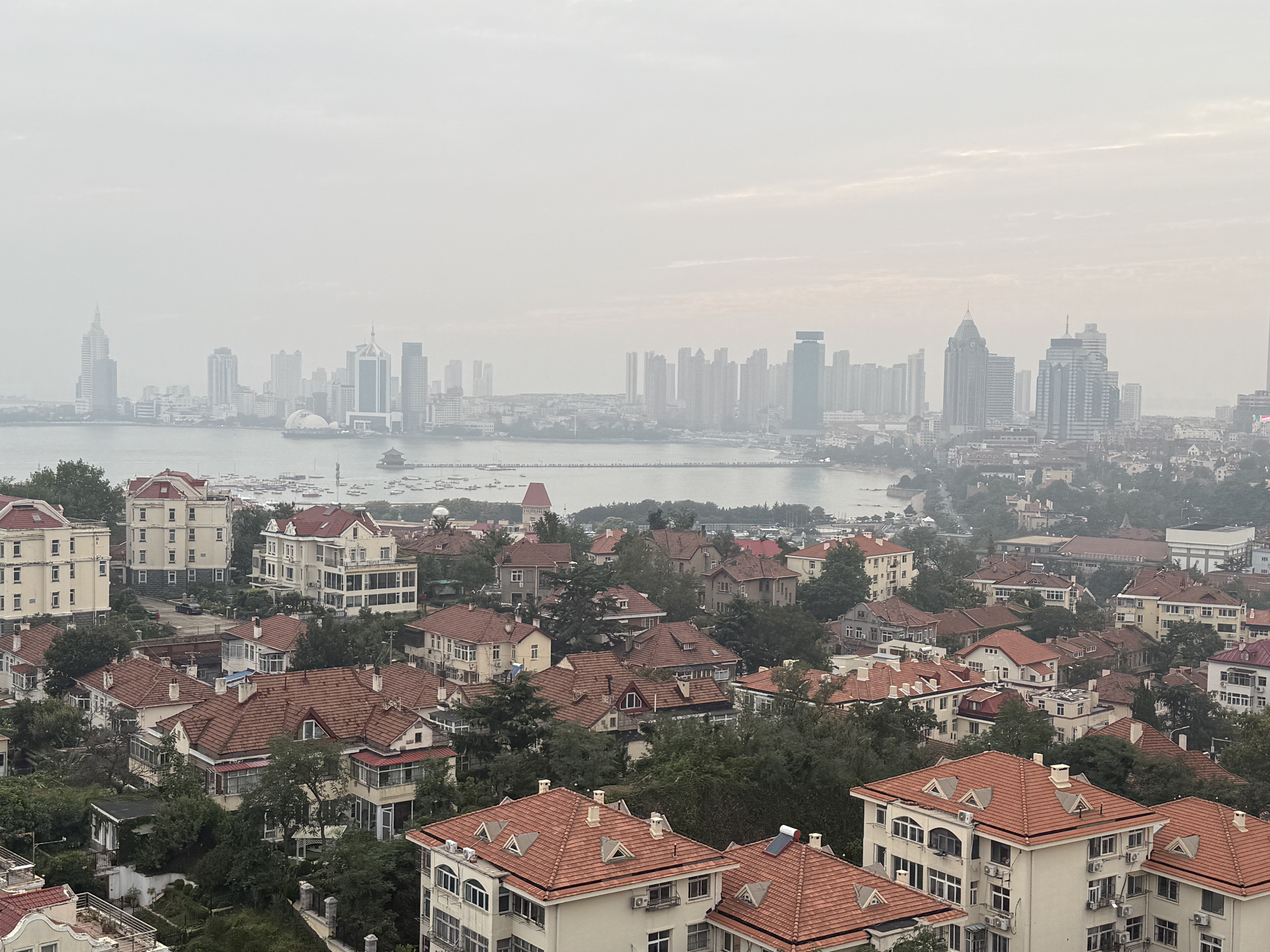 Qingdao's signature red-tiled rooftops set against the modern skyline and the blue expanse of the sea, September 2025. Zaruhi Poghosyan/ CGTN