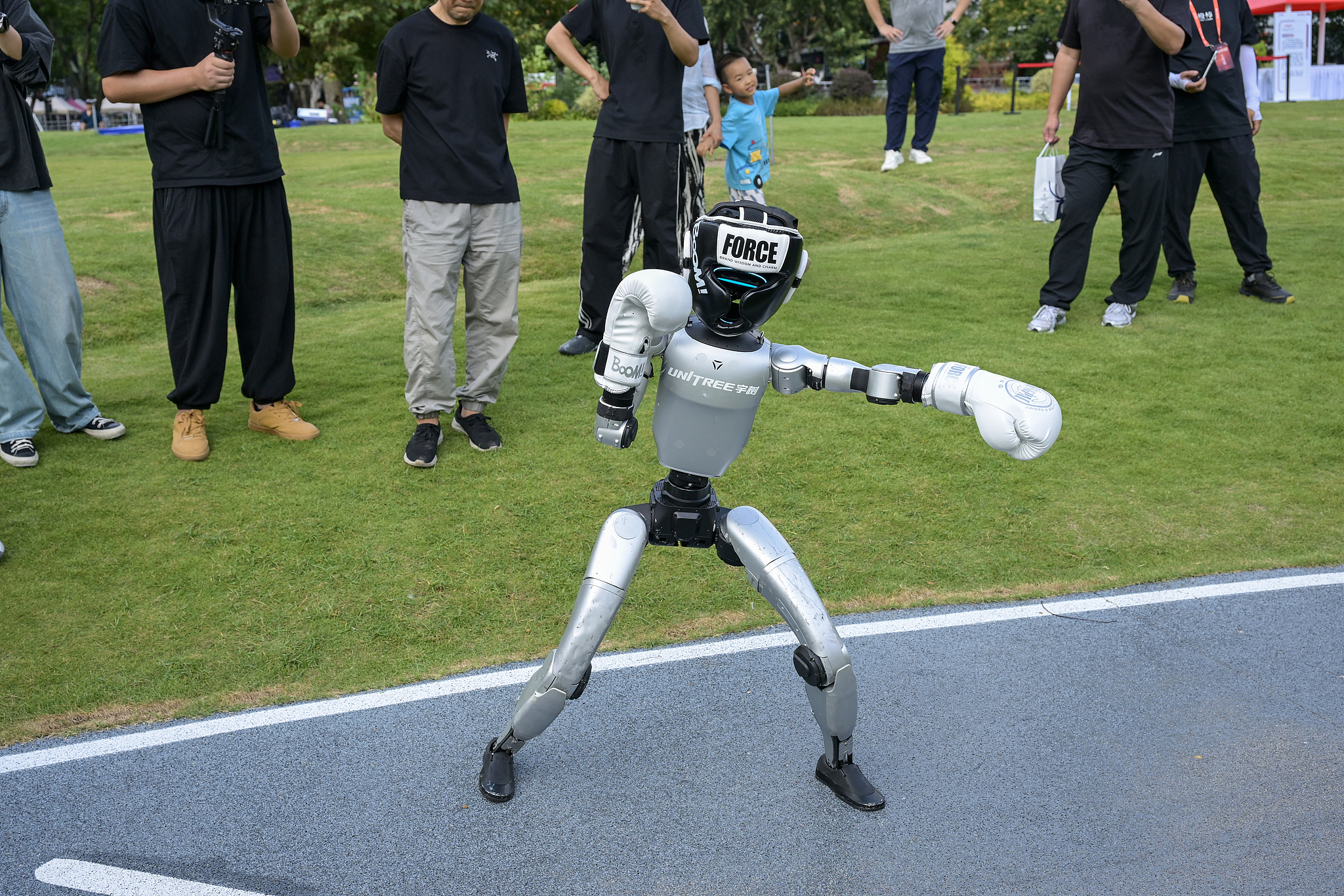 A small humanoid robot captured in a boxing motion at a park in Hangzhou, China's Zhejiang Province, Oct 17, 2025. /VCG