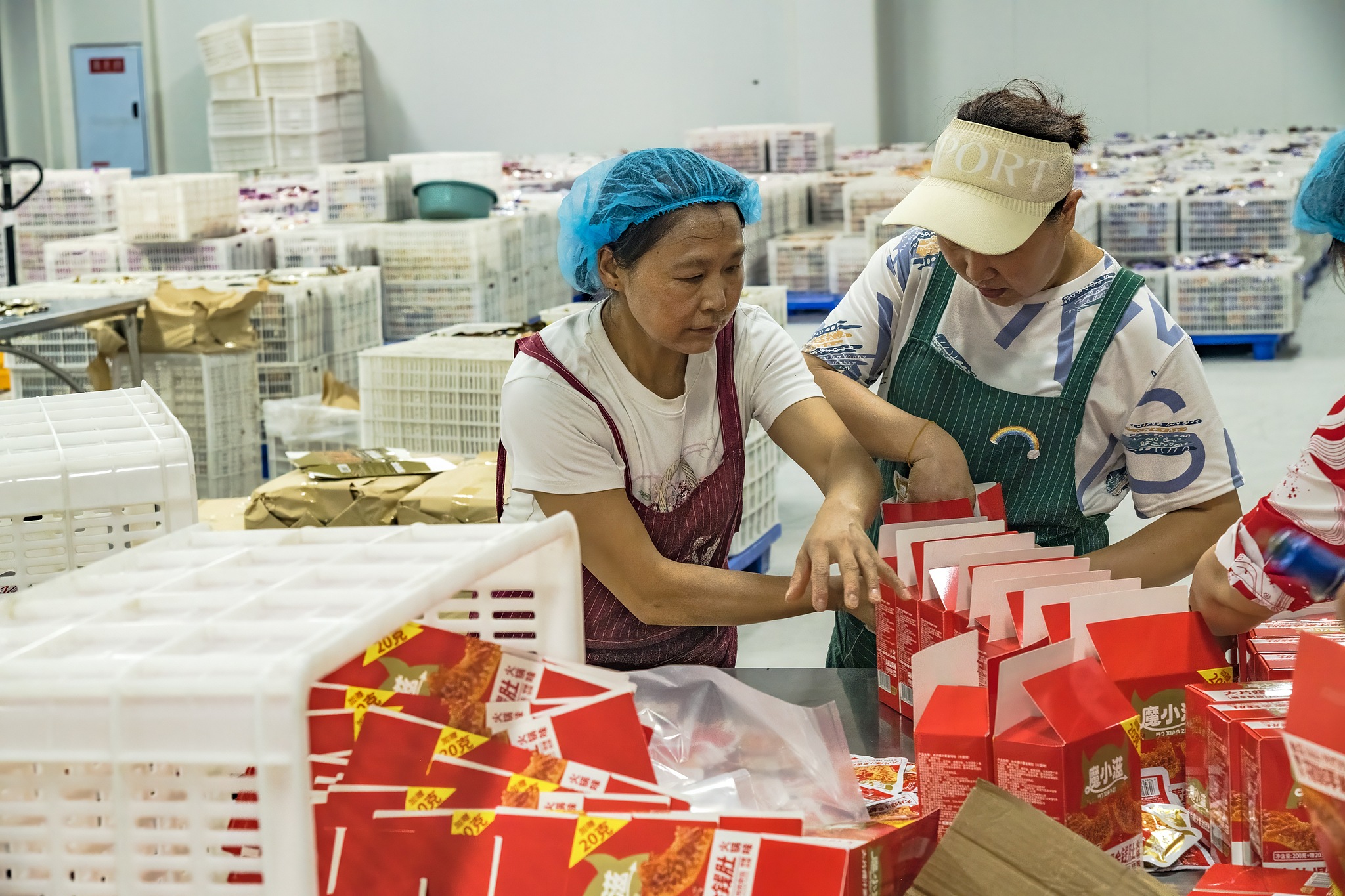 Workers packaging products in a warehouse at Chunzai Industrial Park, China's Sichuan Province, Aug 22, 2025. /VCG