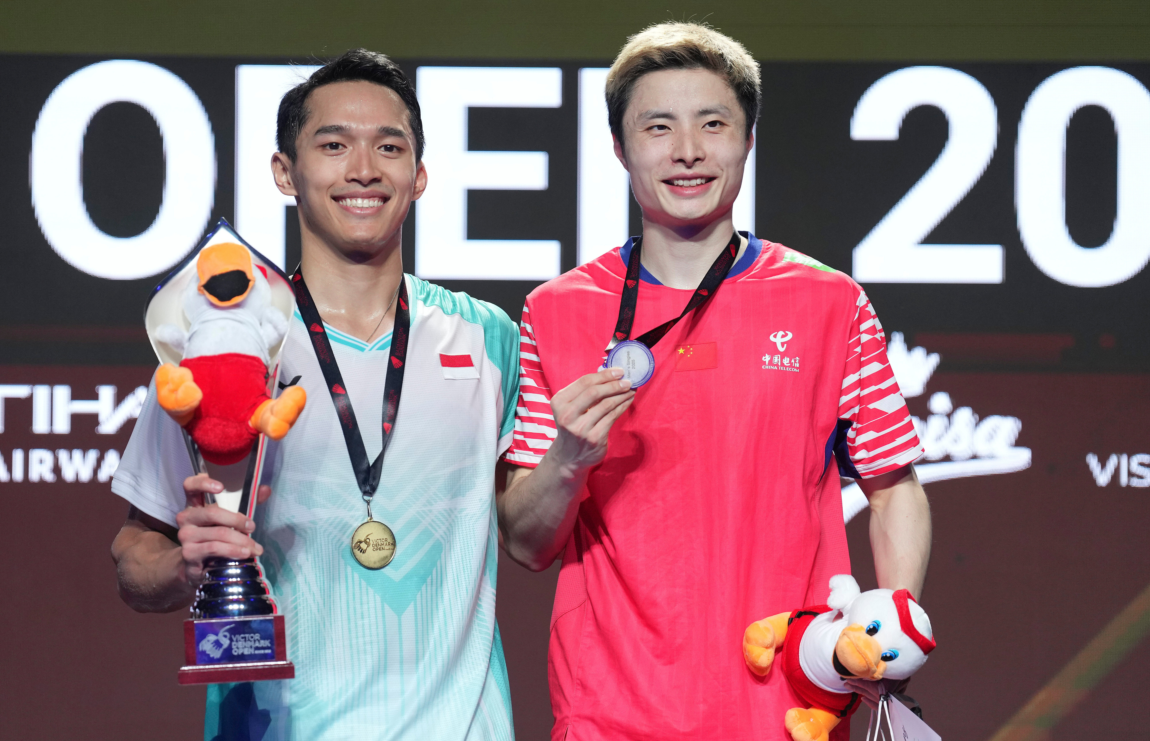 Indonesia's Jonatan Christie (L) and China's Shi Yuqi display their awards after the men's singles final at the BWF Denmark Open in Odense, Denmark, October 19, 2025. /VCG