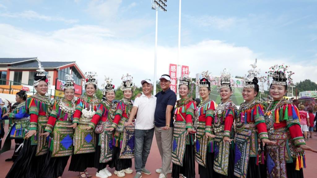 Tourists and cheerleading squad in ethnic costumes pose for photo during the restart ceremony of the 