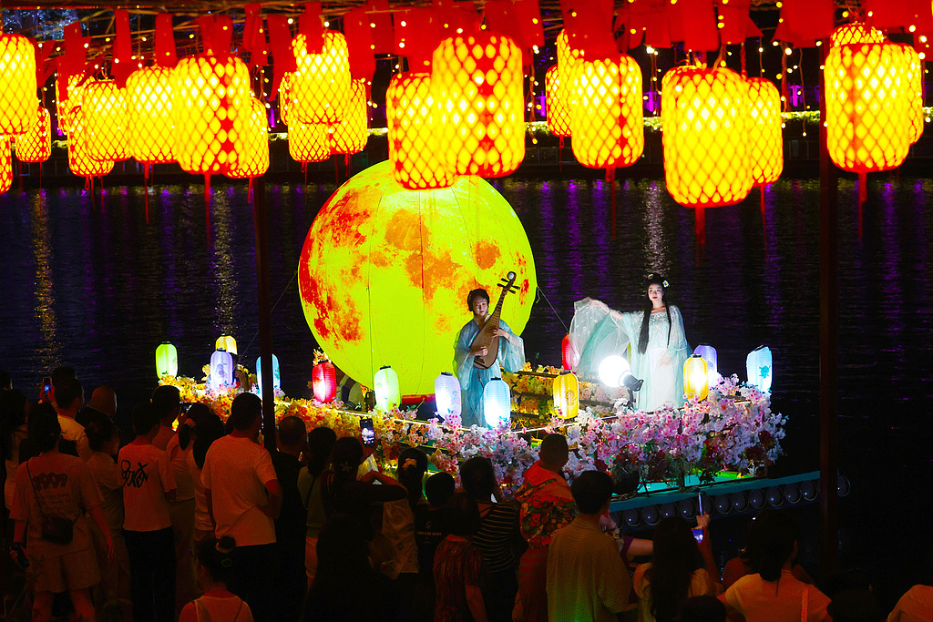 Two women in hanfu costumes perform on a lantern-decorated boat in Chongqing, at night on October 6, 2025. /VCG