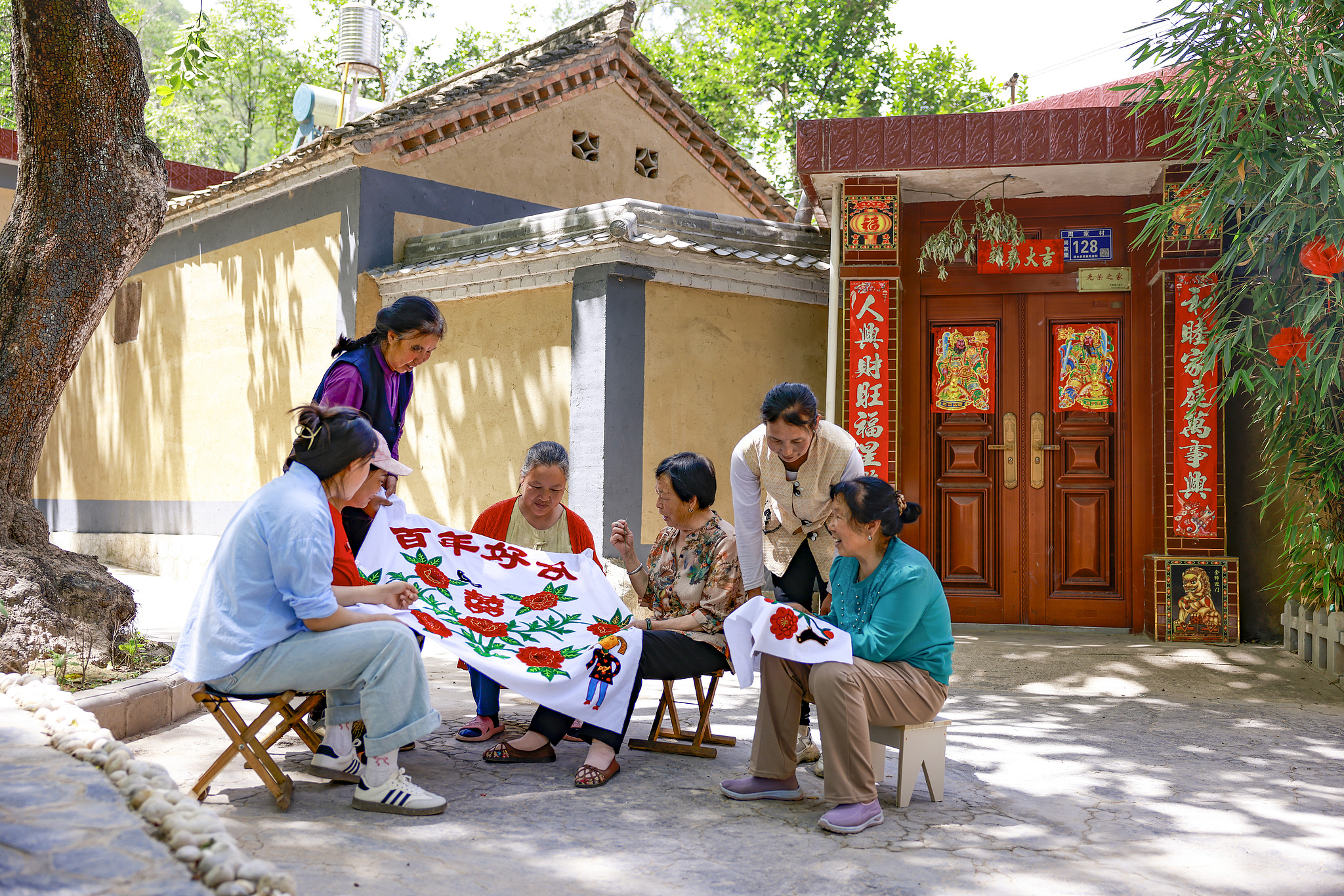 A file photo captures the moments of villagers chatting over needlework in Tianshui, Gansu Province. /VCG
