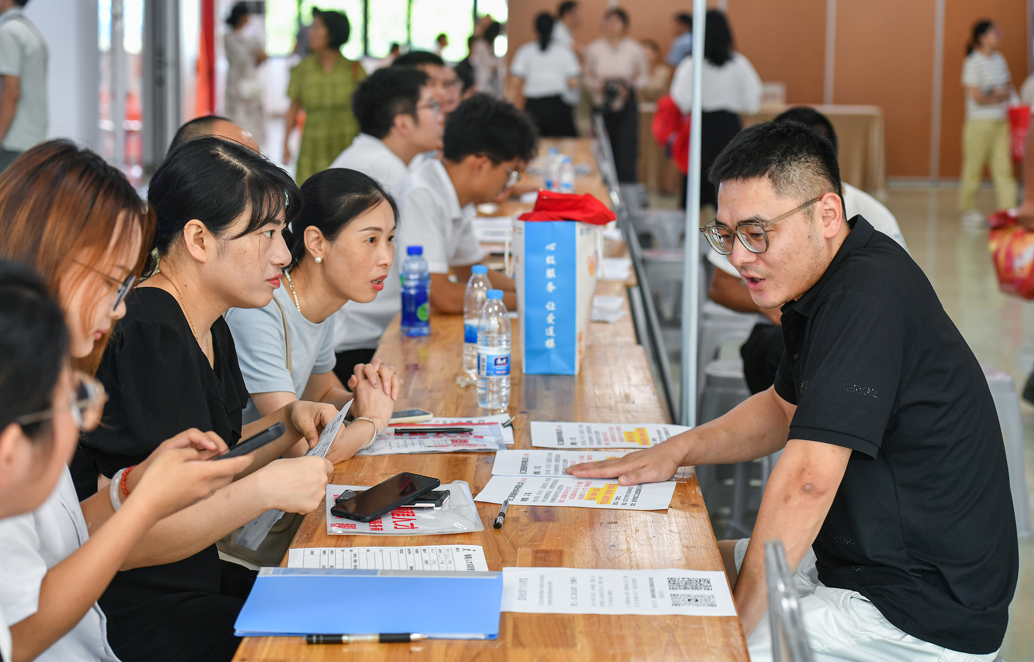 College graduates talk with prospective employers at a local job fair in Jinhua, Zhejiang Province, China, July 18, 2024. / CFP