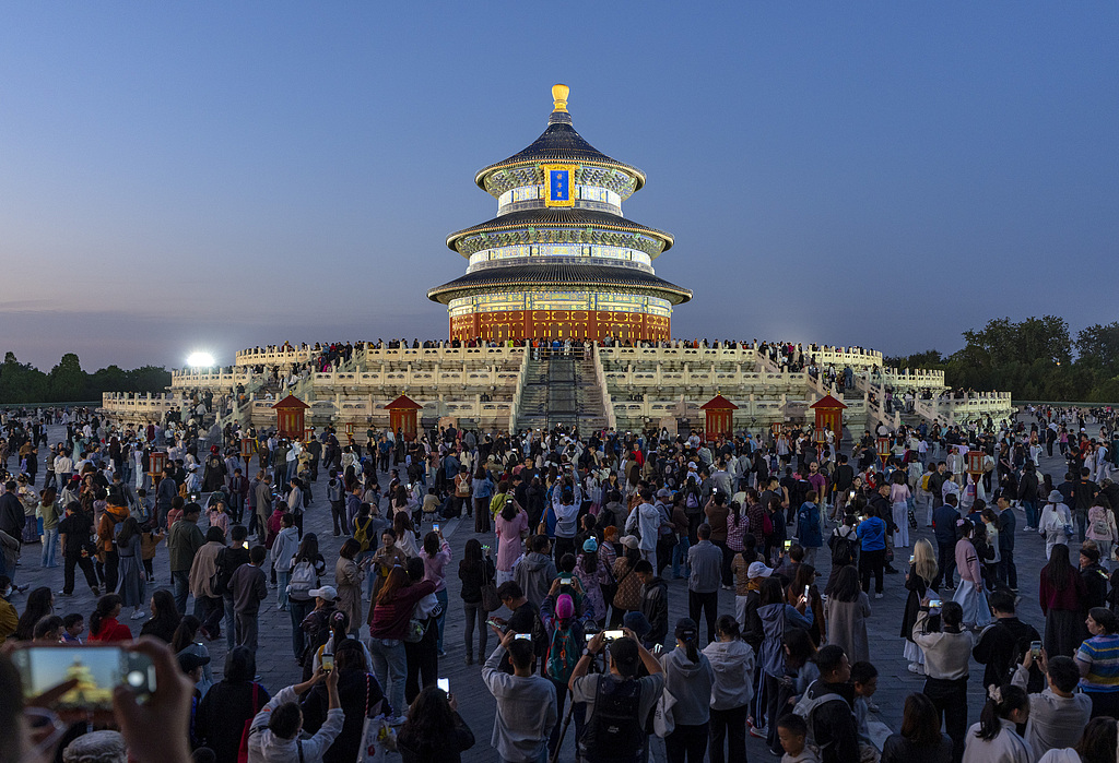 The Hall of Prayer for Good Harvests in Beijing's Temple of Heaven Park is illuminated on October 6, 2025, attracting a large number of tourists to admire and capture the moment. /VCG