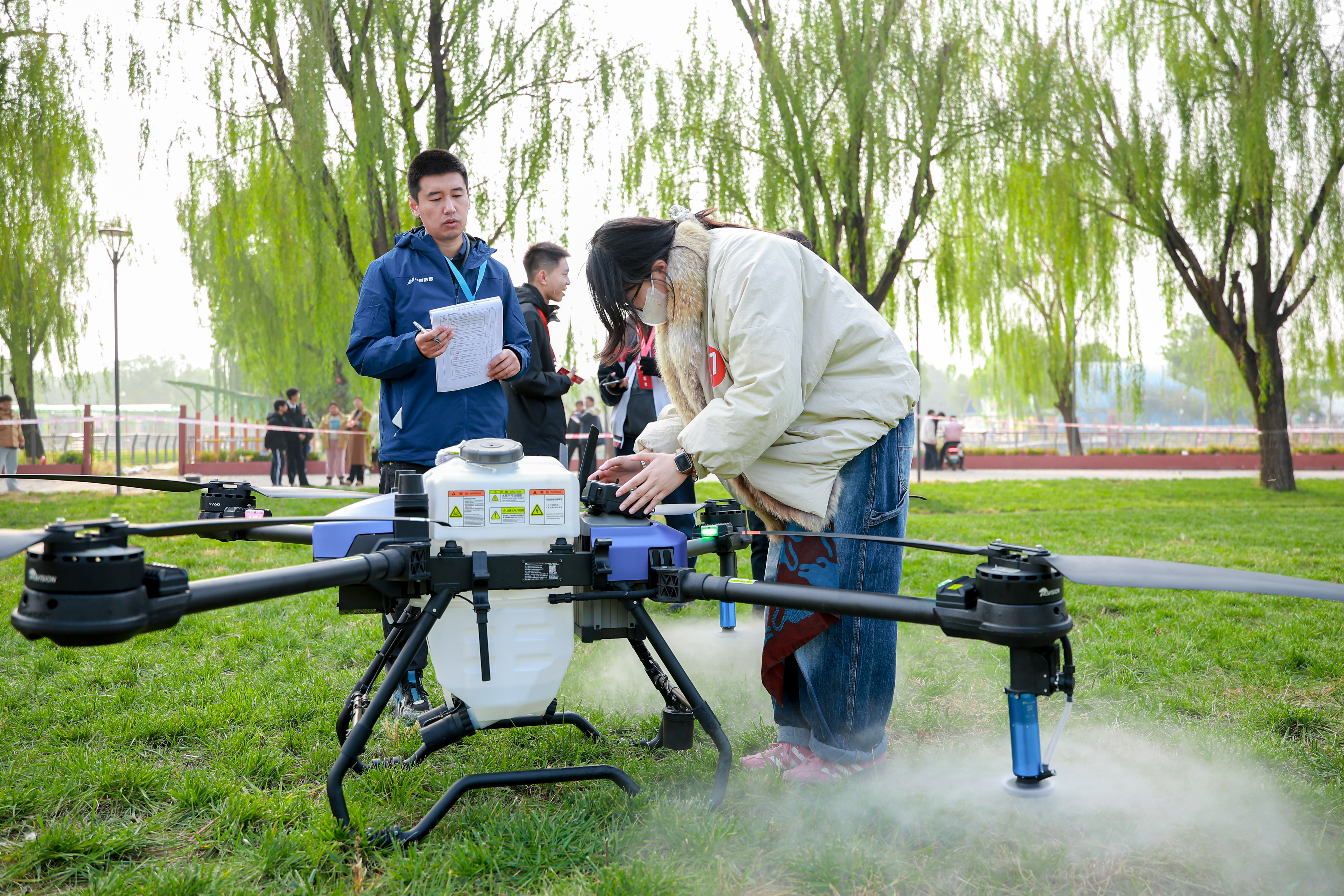 A young pilot prepares a drone at a competition set against the backdrop of a real-world farming environment. The competition was part of an initiative by Beijing’s Chaoyang District to deepen the 