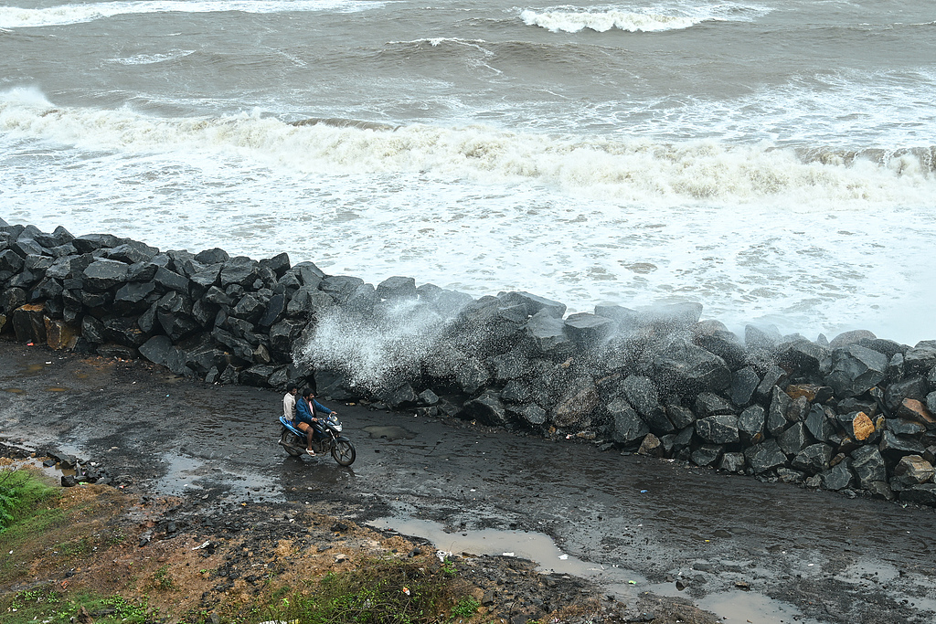 A motorist drives past boulders recently installed along the coastline to protect against high tides during Cyclone Montha, in the Kakinada district of Andhra Pradesh, India, October 28, 2025. /CFP