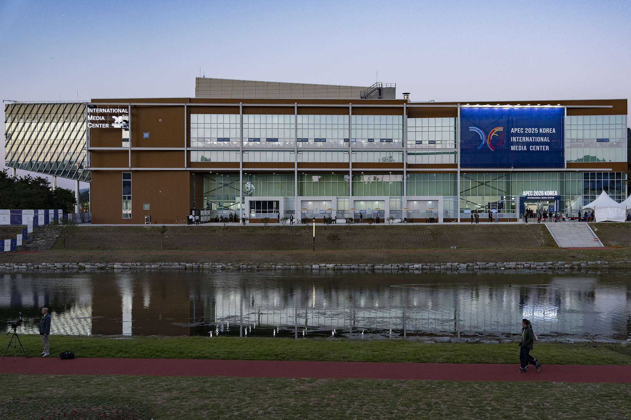 Journalists covering the 32nd APEC Economic Leaders' Meeting walk in front of the Gyeongju APEC International Media Center in the Republic of Korea, October 29, 2025. / CFP