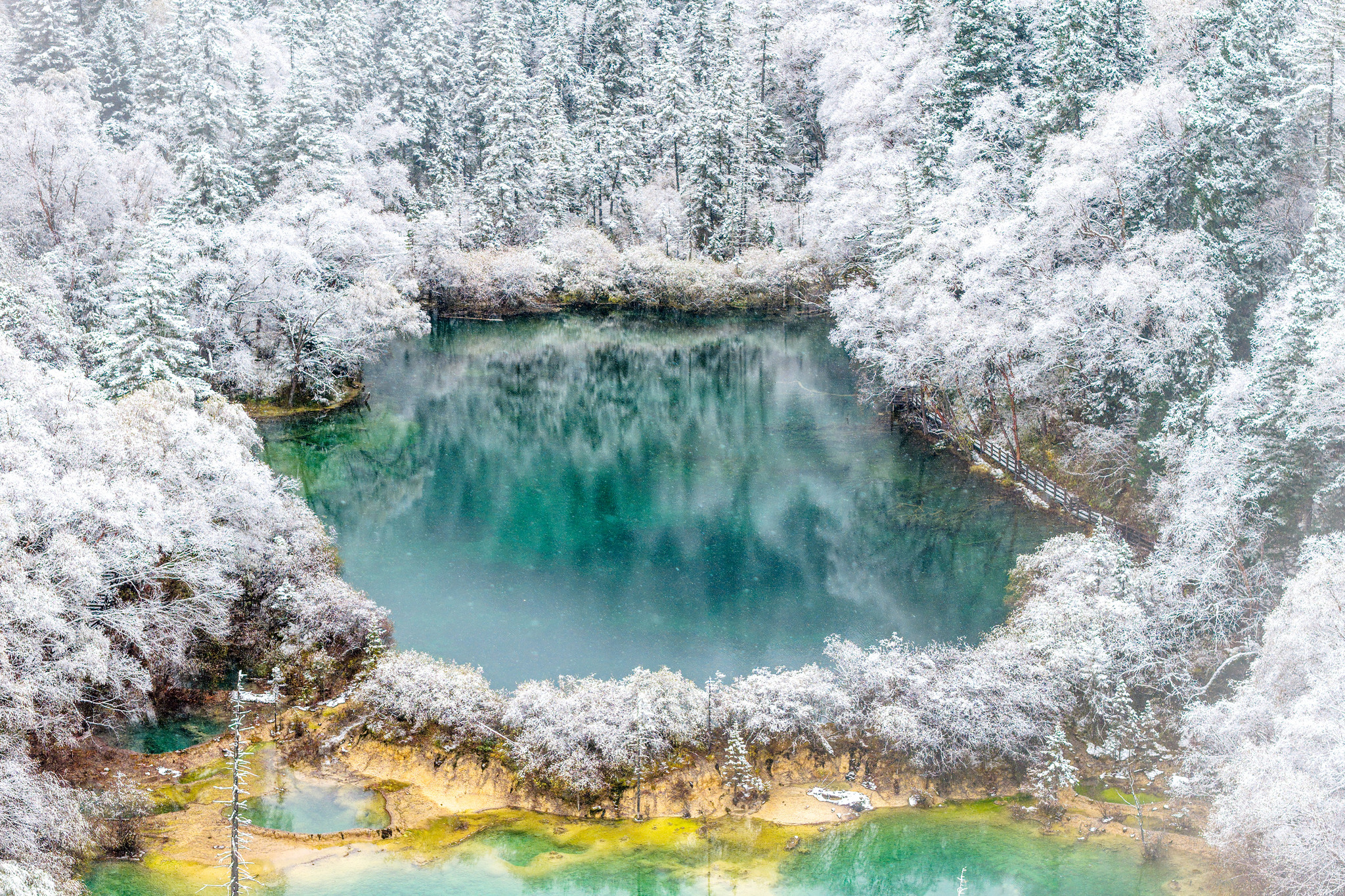 The first snowfall of the autumn season blankets the Jiuzhaigou scenic area in Sichuan Province, enhancing the beauty of its crystal-clear pools on October 31, 2025. /VCG