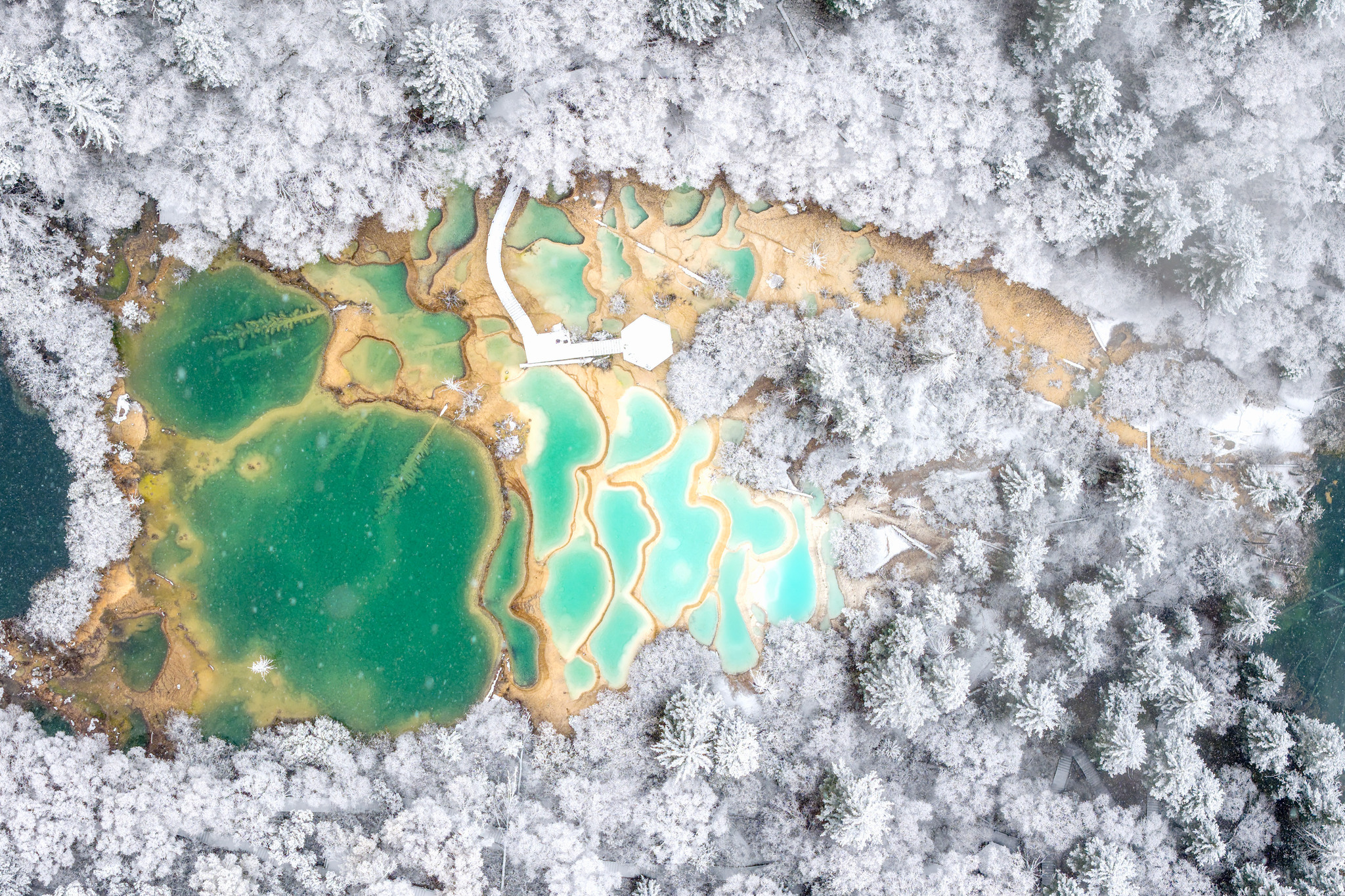 The first snowfall of the autumn season blankets the Jiuzhaigou scenic area in Sichuan Province, enhancing the beauty of its crystal-clear pools on October 31, 2025. /VCG