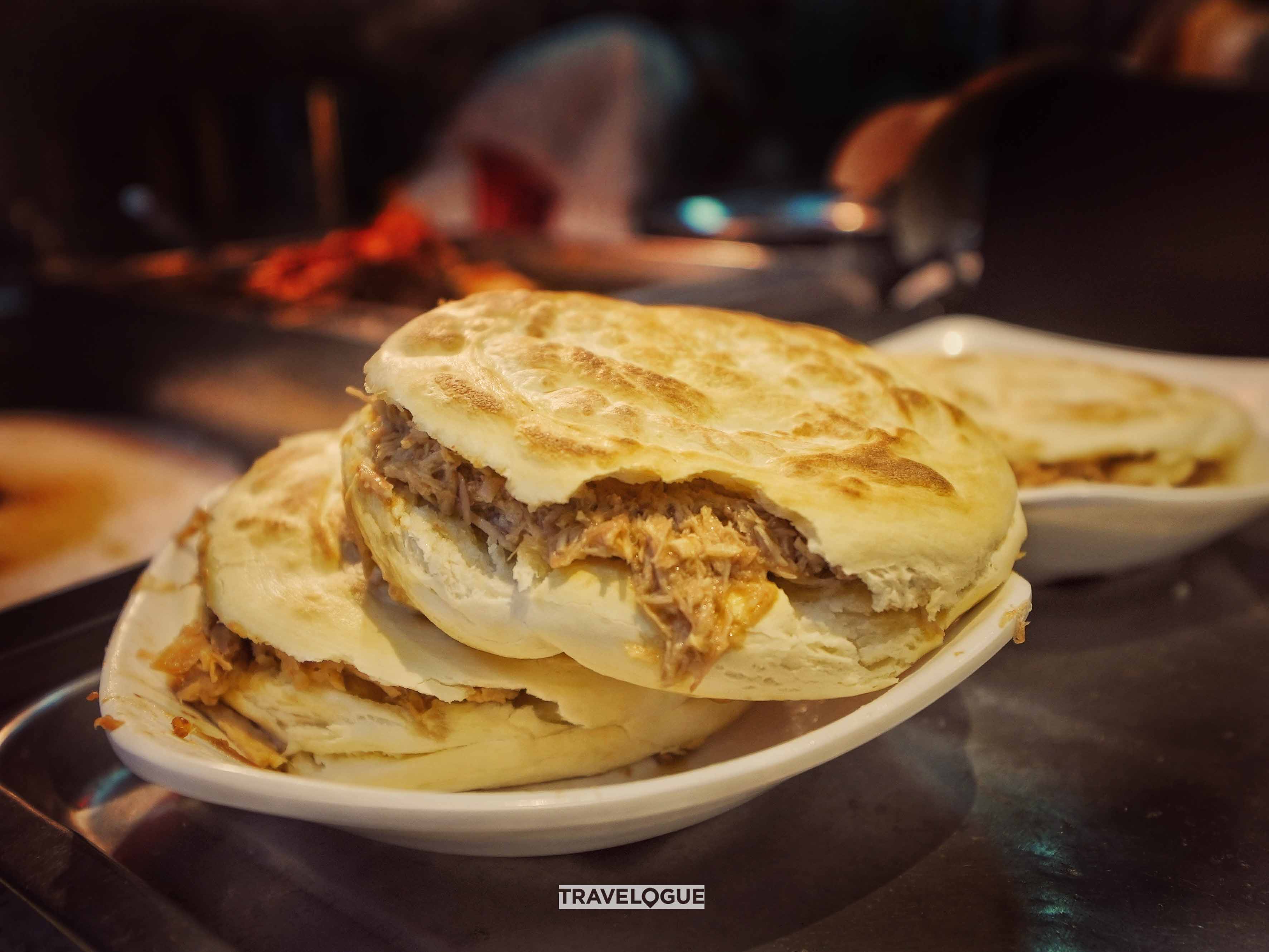 Roujiamo is a crispy “sandwich” with tender, marinated pork from Xi'an. /CGTN
